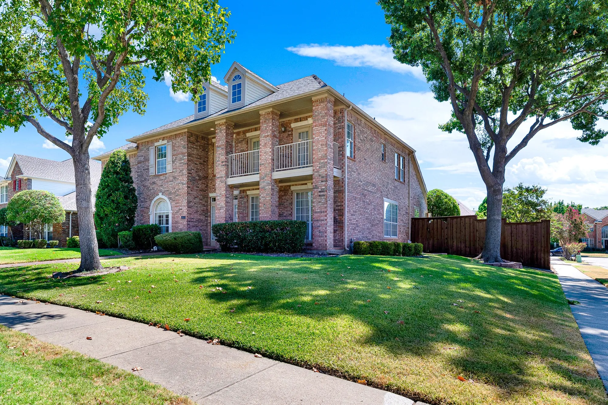 Situated on a large corner lot, mature shade trees frame a manicured front lawn and concrete walkway leading up to the entrance. Enjoy quiet neighborhood walks right outside your front door.