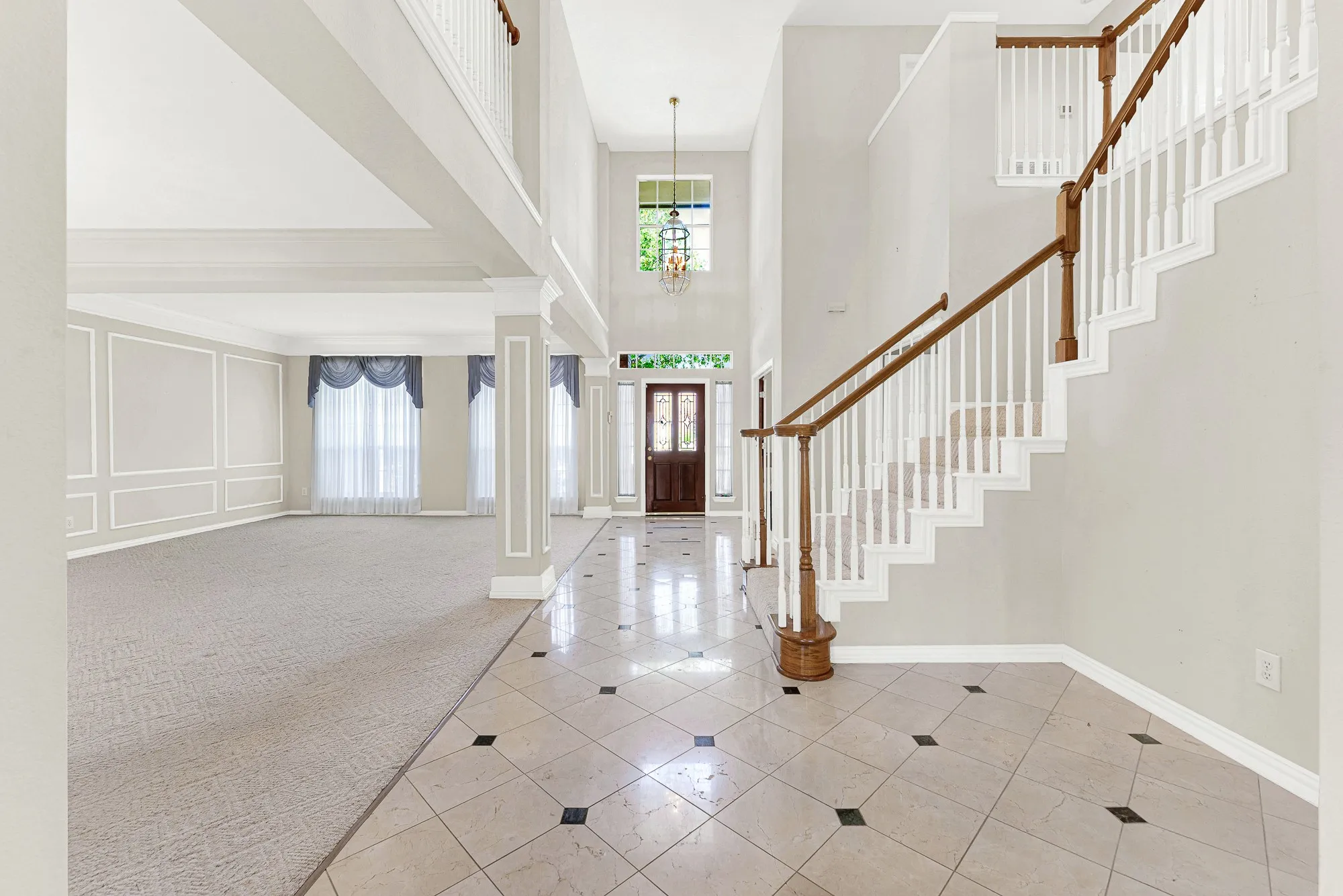 Soaring two-story ceilings and polished tile floors reflect light throughout this open entry, anchored by a traditional wooden staircase. It’s the perfect spot to warmly welcome guests as they arrive for an evening celebration.