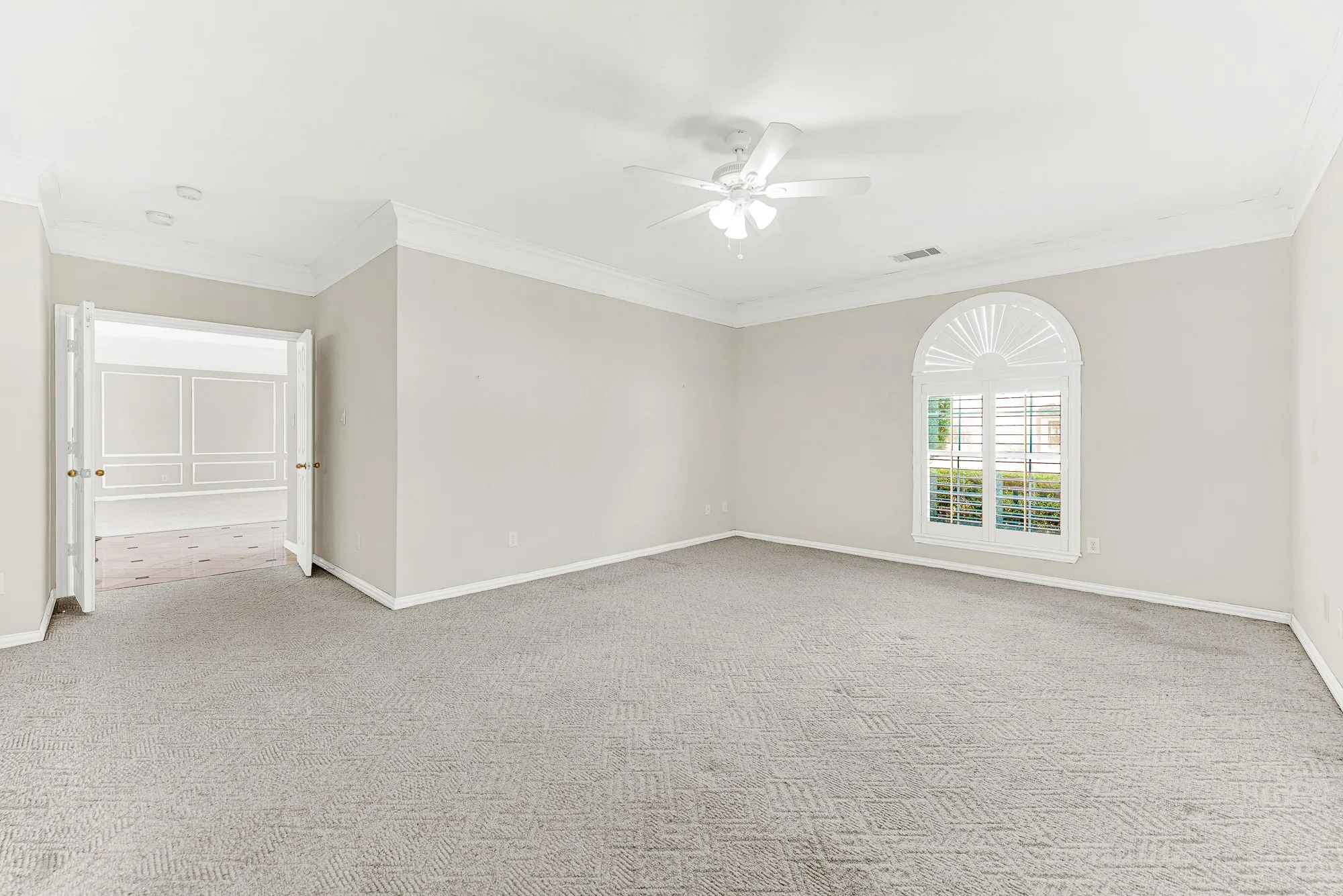 Double doors lead seamlessly out toward the foyer, highlighting the generous floor layout. Imagine slipping away here for a quiet afternoon nap