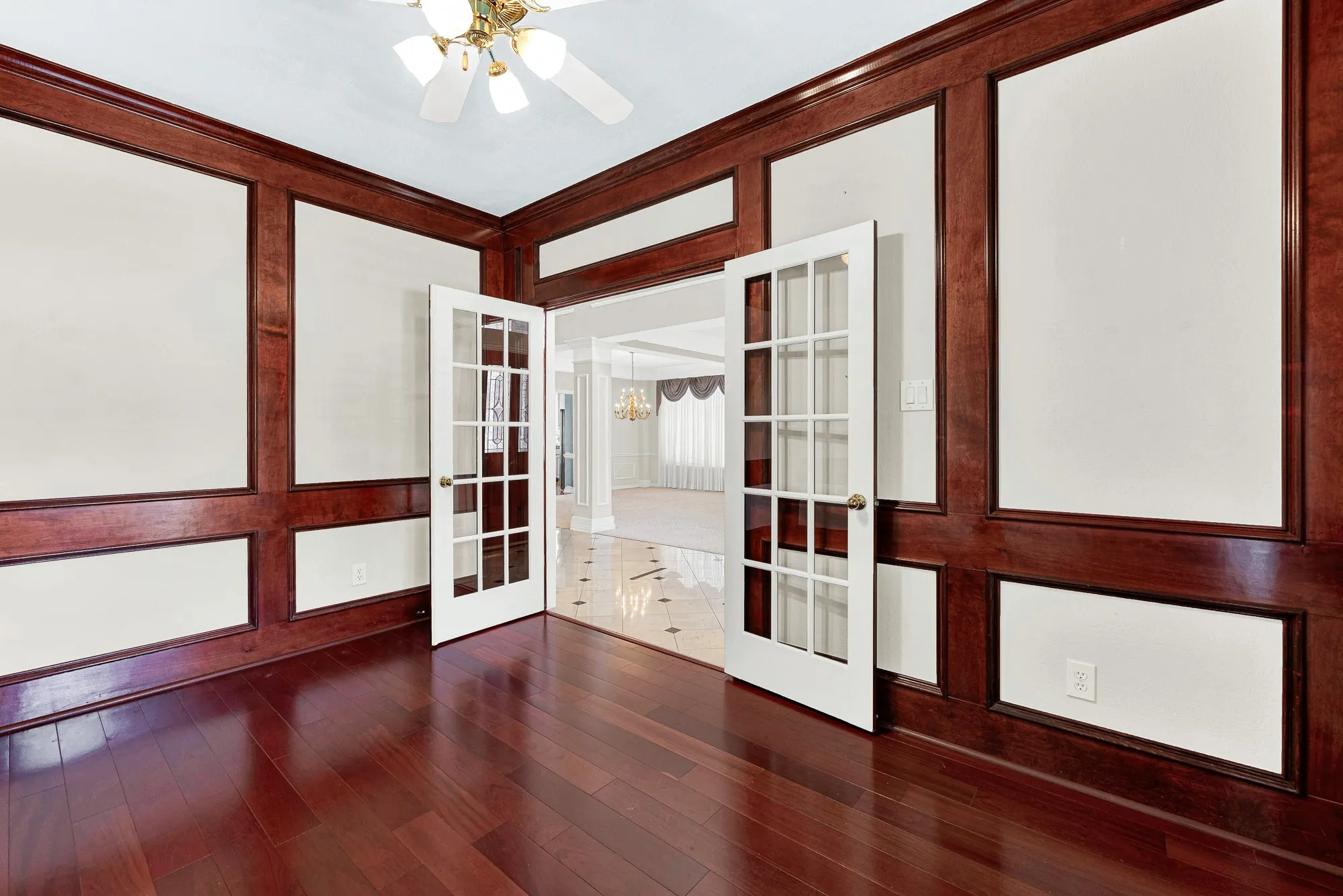 Multi-pane French doors open wide to connect this workspace with the luminous hallway. Close the glass panels for a quiet afternoon retreat when you need deep focus.