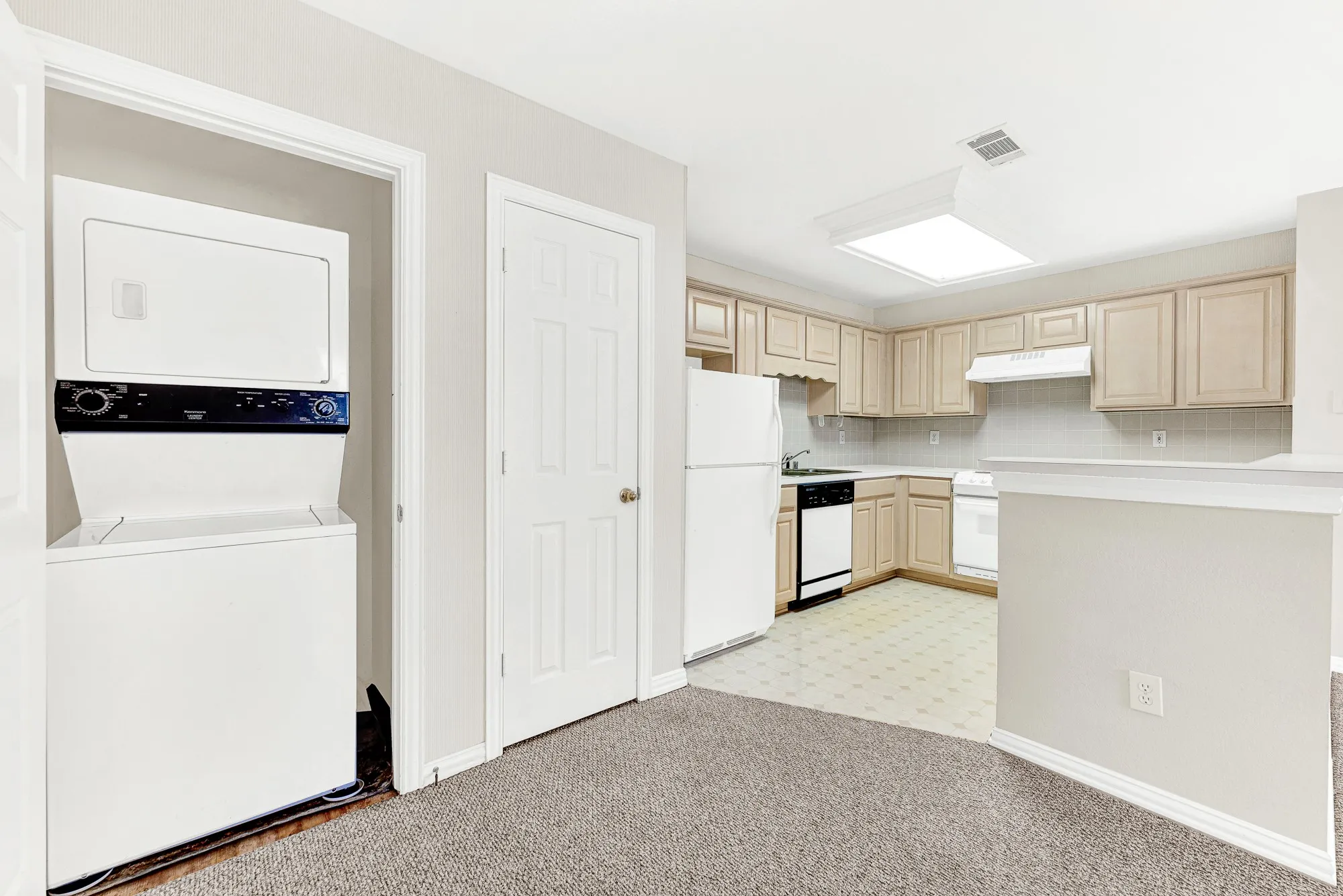 A dedicated utility closet tucked right beside the kitchen holds a stacked washer and dryer setup. Handle laundry day effortlessly without having to carry baskets downstairs.