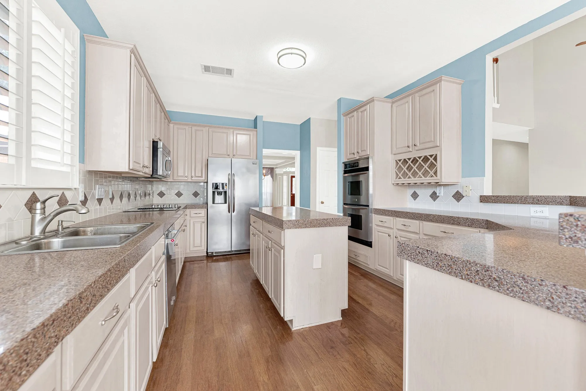 FABULOUS REMODEL OPPURTUNITY!!! Soft blue accent walls pop against beige cabinetry and a central prep island. It's a wonderful setup for pulling out fresh ingredients to craft gourmet weekend meals.