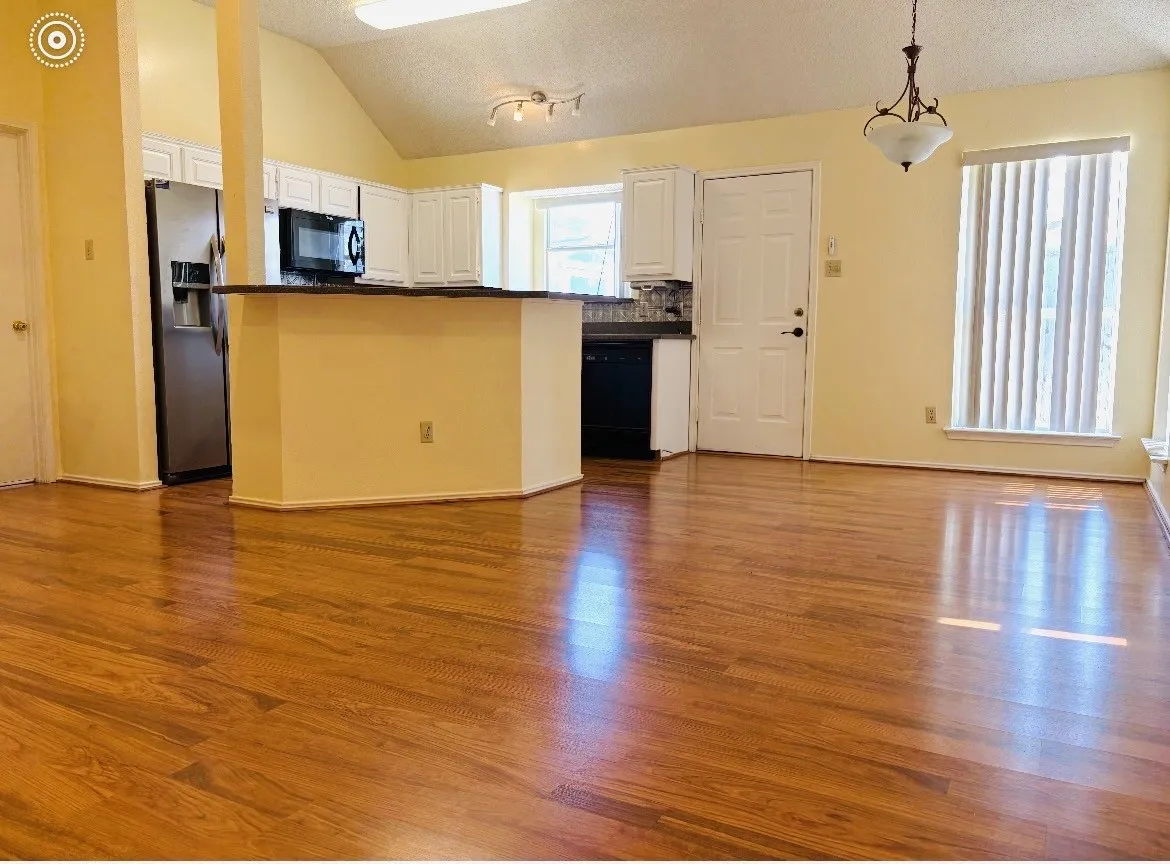Wood-finish flooring throughout, vaulted ceiling, and recessed lighting