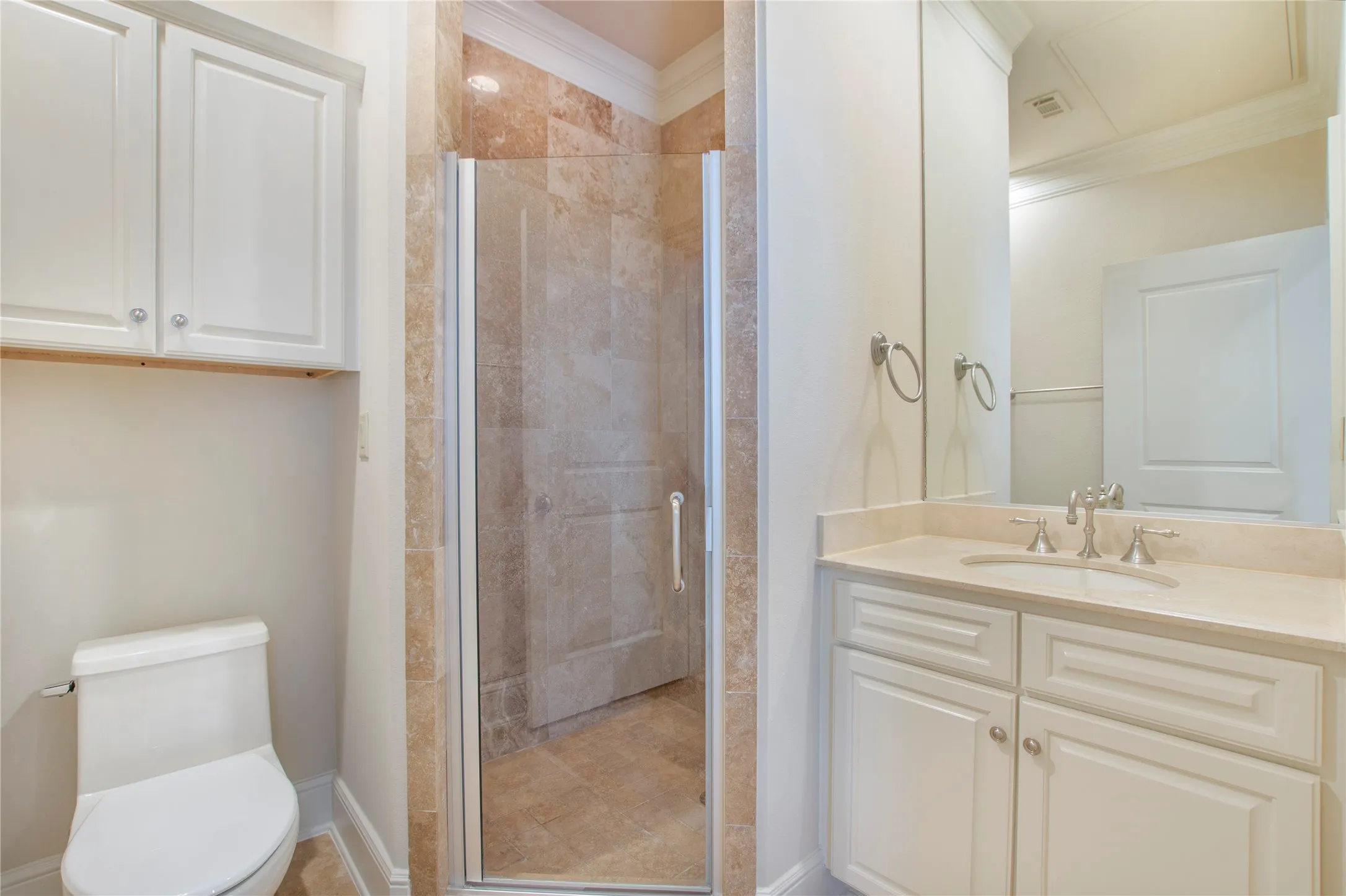 Bathroom featuring toilet, ornamental molding, walk in shower, and vanity