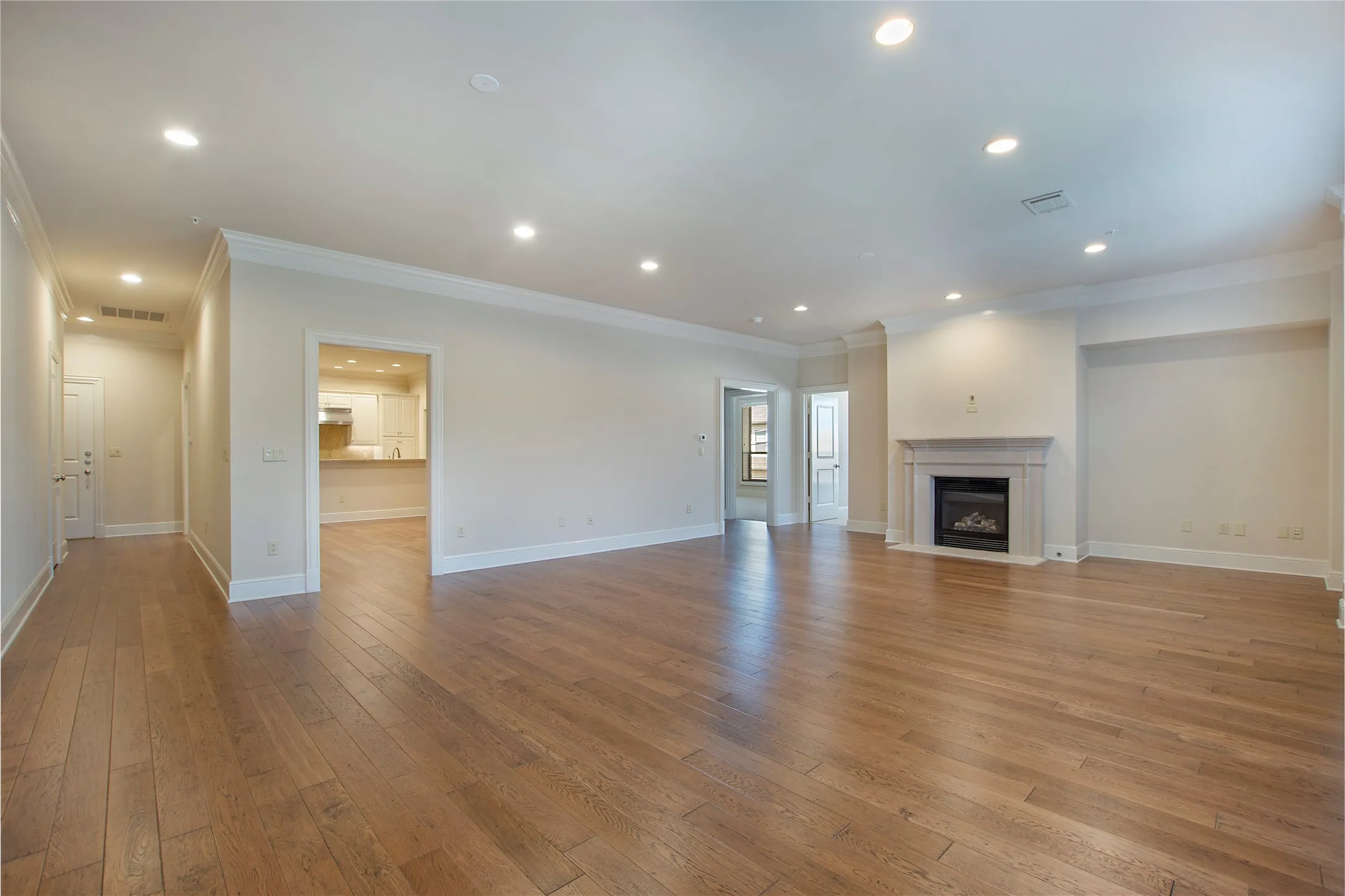 Unfurnished living room featuring ornamental molding and light wood-type flooring
