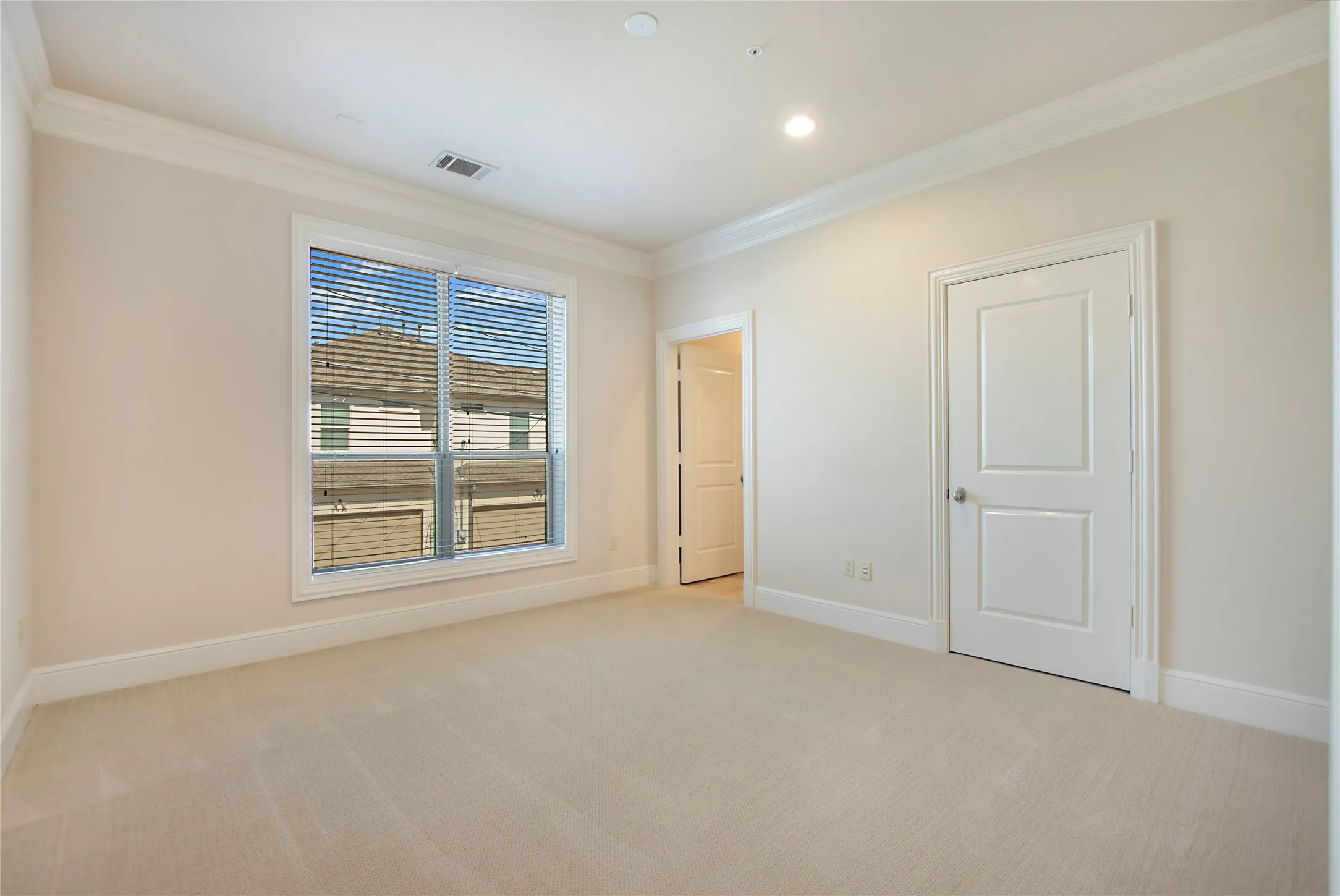 Carpeted spare room featuring crown molding