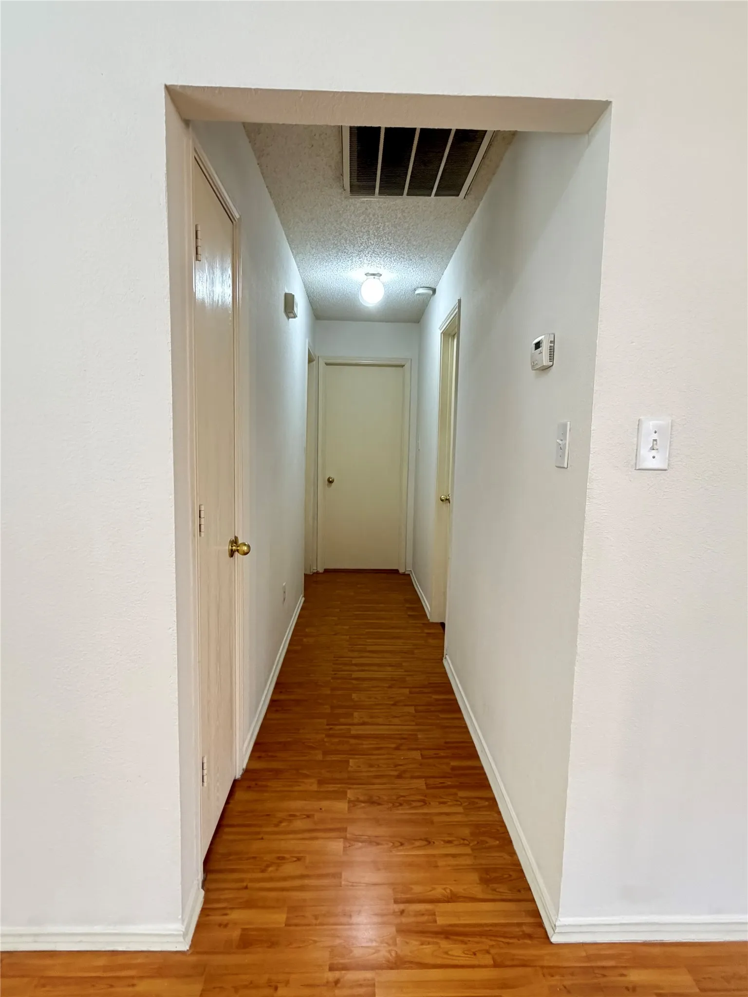 Wood-finish flooring throughout the hallway