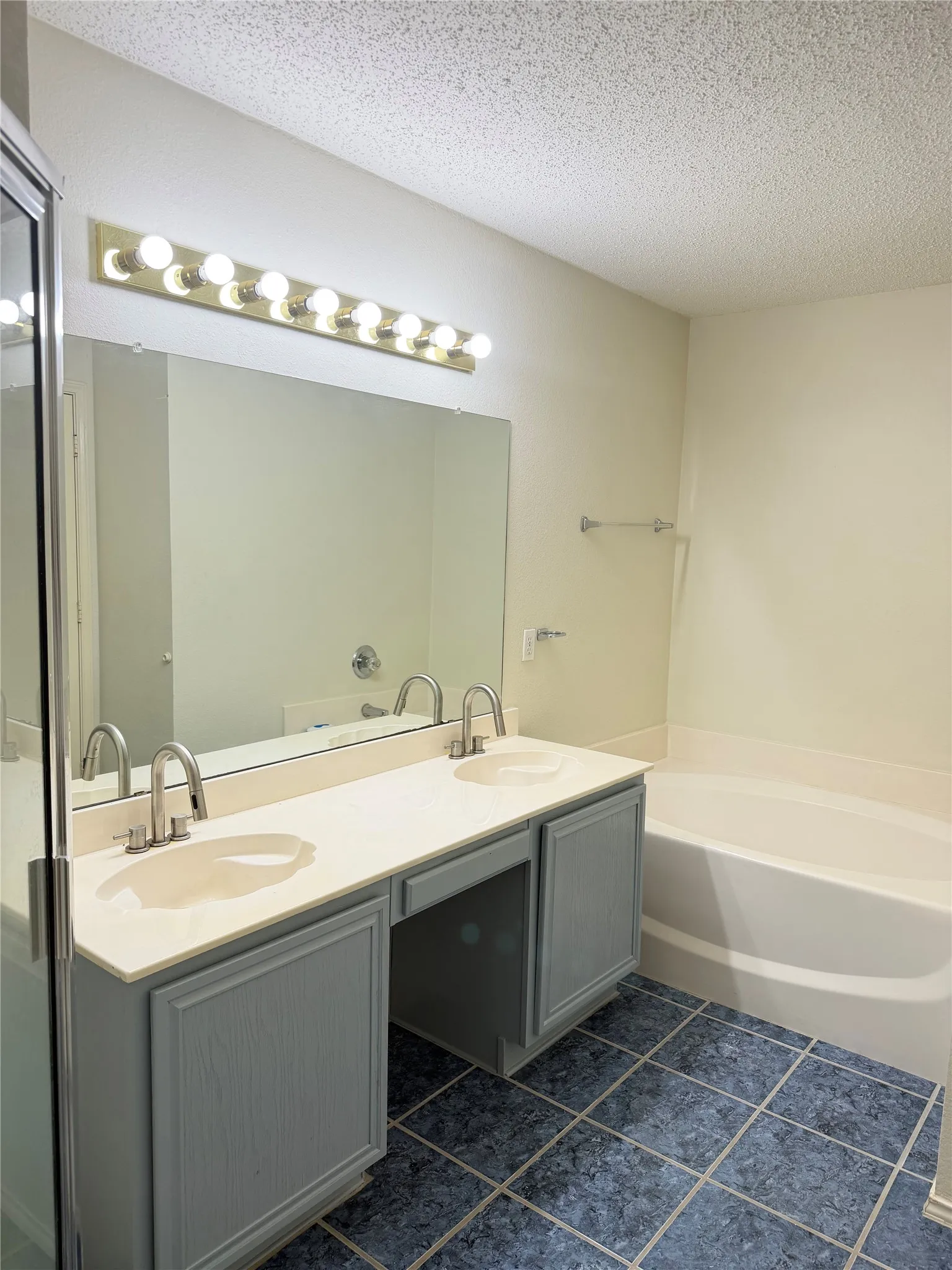 Dual vanity with integrated sinks, light-colored countertop, and gray wood-finish cabinetry