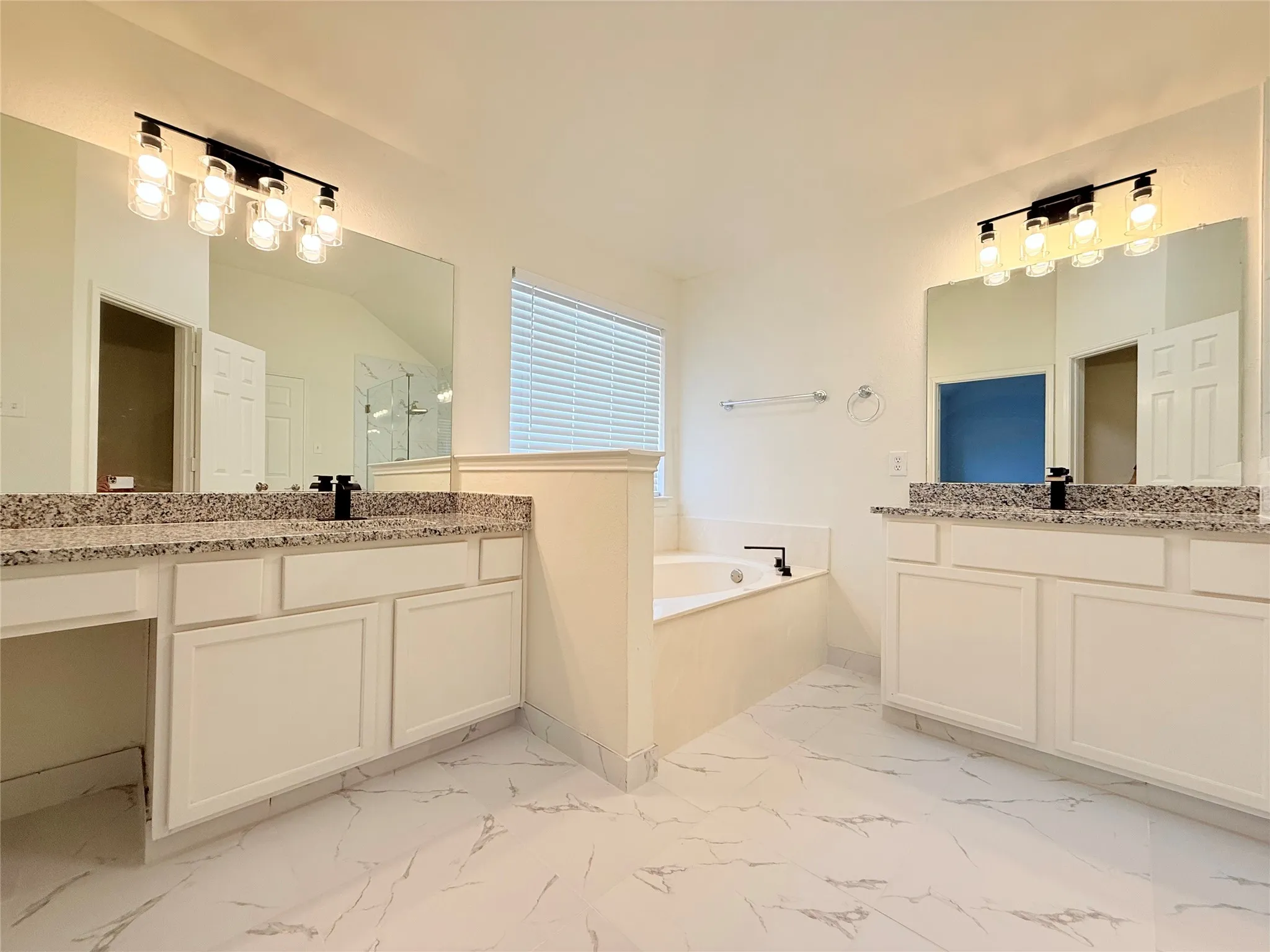 Dual vanities with granite countertops, undermount sinks, and matte black fixtures