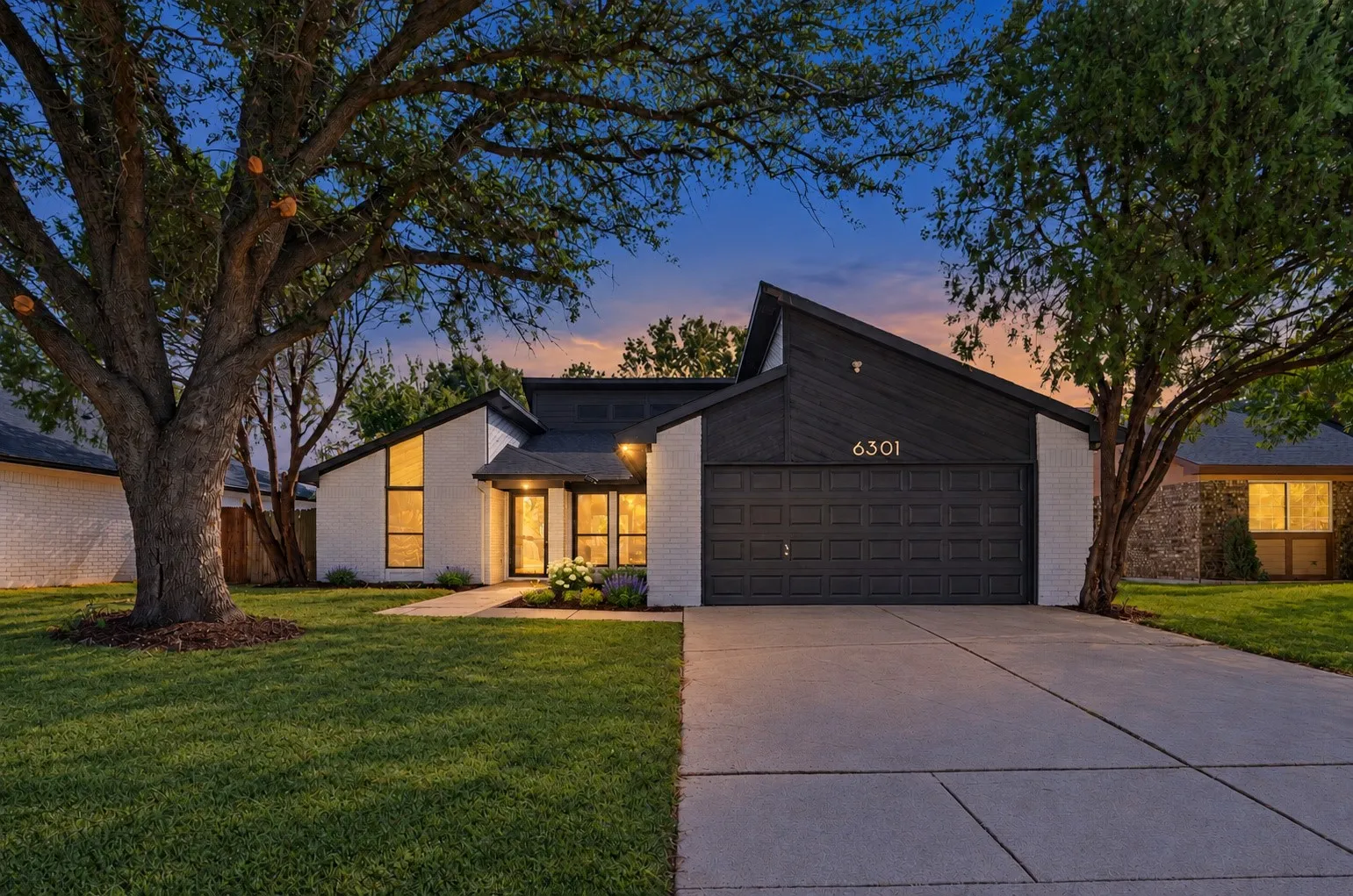 Contemporary facade with white brick, dark siding, and an attached two-car garage