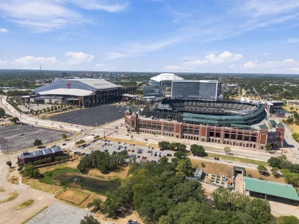 Aerial perspective showcasing multiple large-scale structures, extensive parking areas, and mature tree coverage