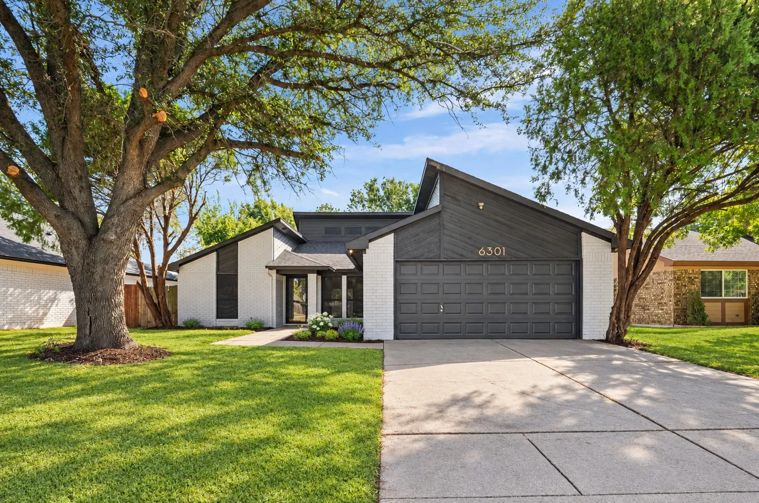 Contemporary exterior featuring white brick and dark-stained wood siding