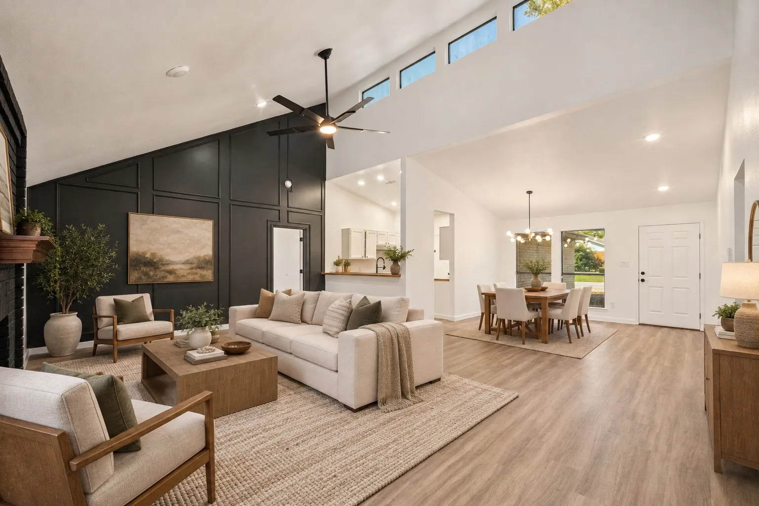 Vaulted ceiling with clerestory windows, wood-finish flooring, accent wall with decorative paneling, recessed lighting, and a modern ceiling fan