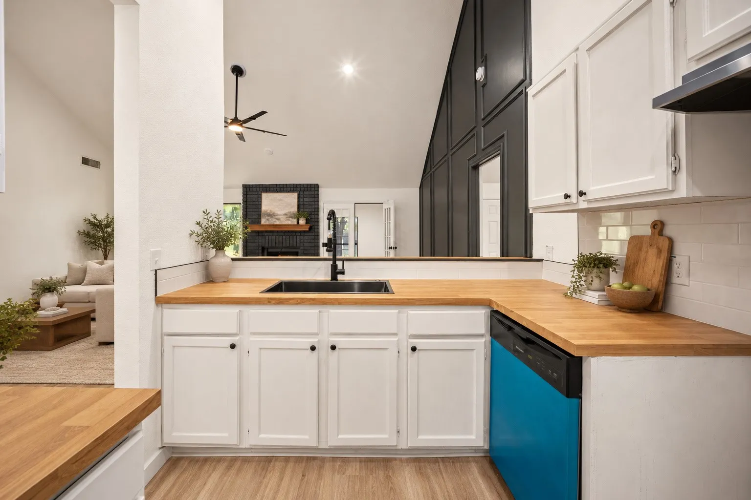 Kitchen featuring wood-finish countertops, white cabinetry, and a subway tile backsplash
