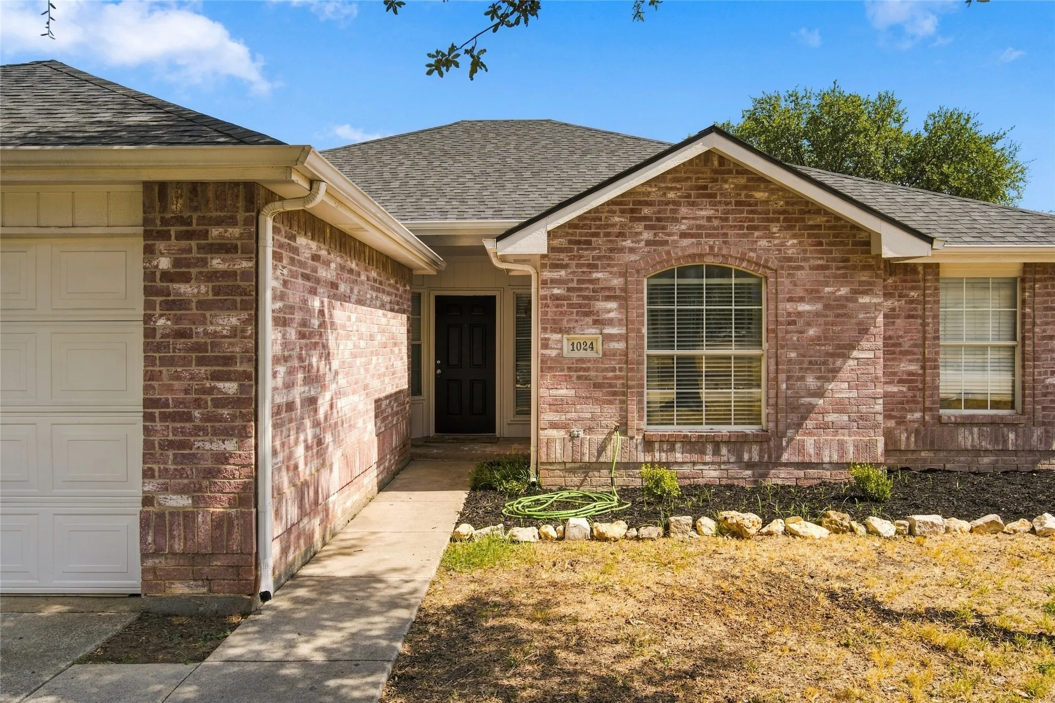 Brick exterior with a dark-paneled garage door