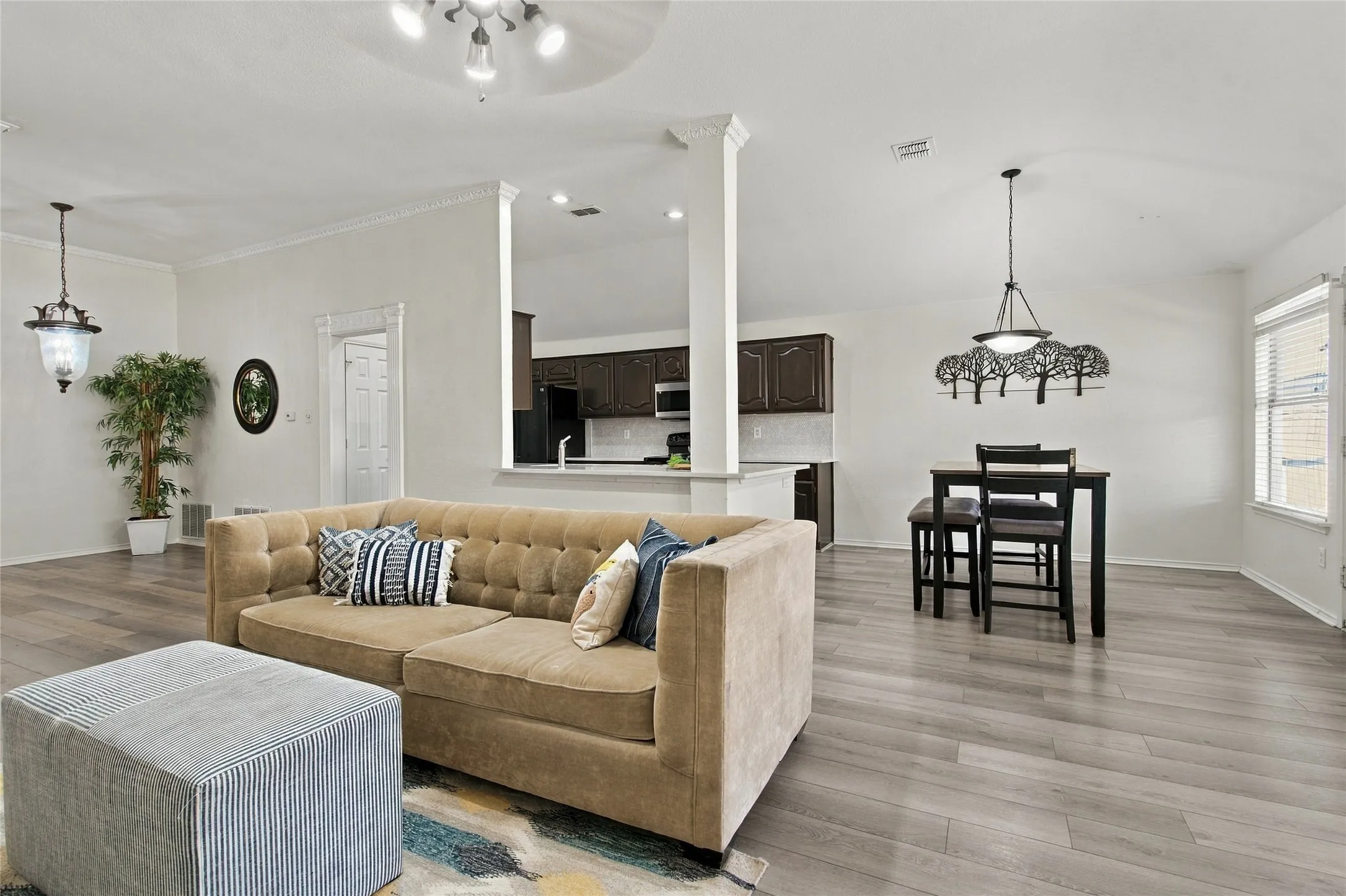 Expansive interior with wood-finish flooring, white walls, and crown molding