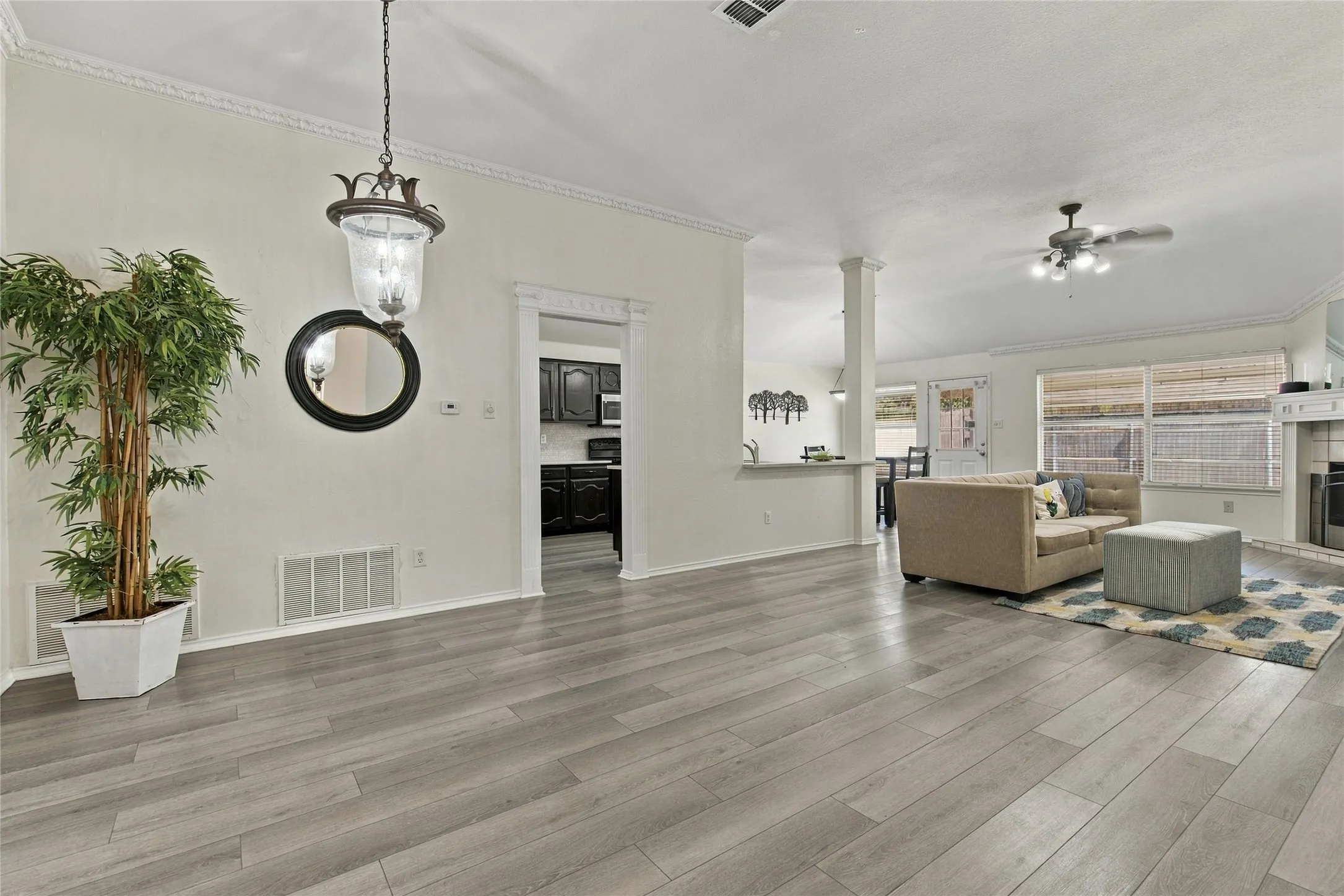Spacious interior with wood-finish flooring, decorative crown molding, and a chandelier