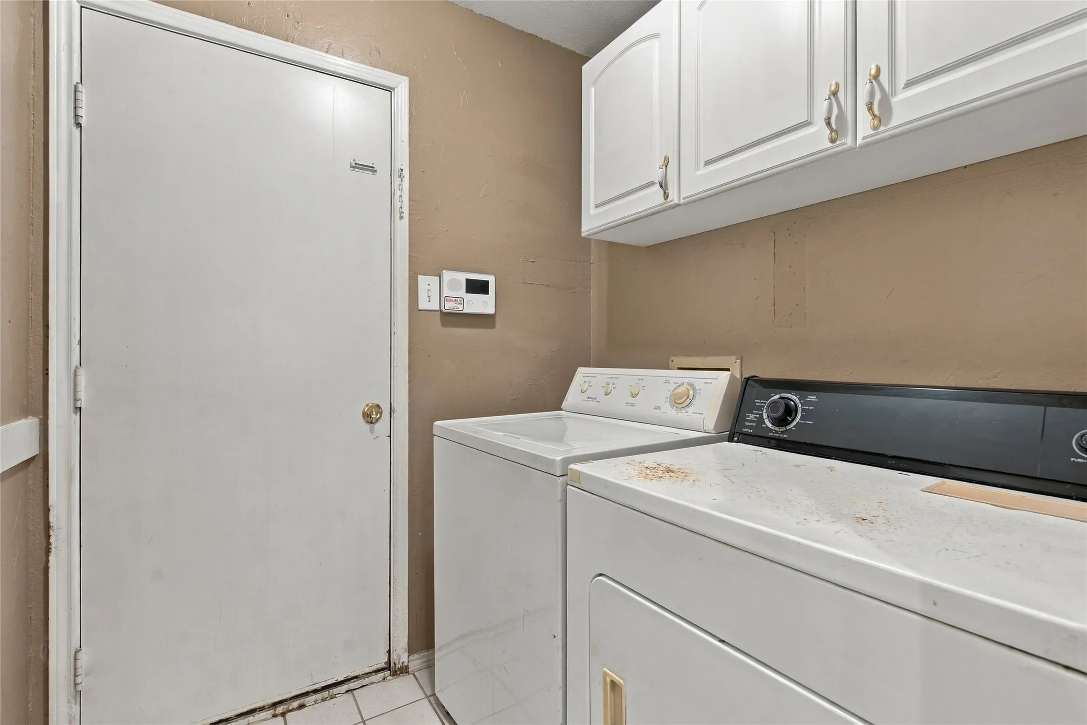 White shaker-style cabinetry with gold-tone hardware
