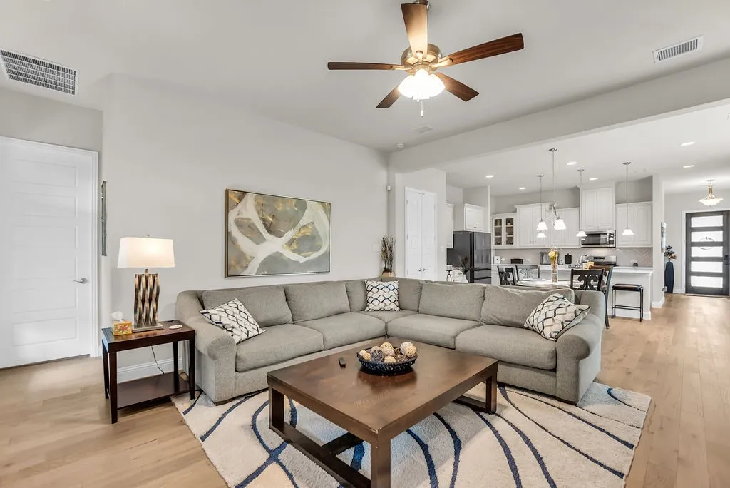 Bright living area featuring wood-finish flooring, a ceiling fan, and recessed lighting