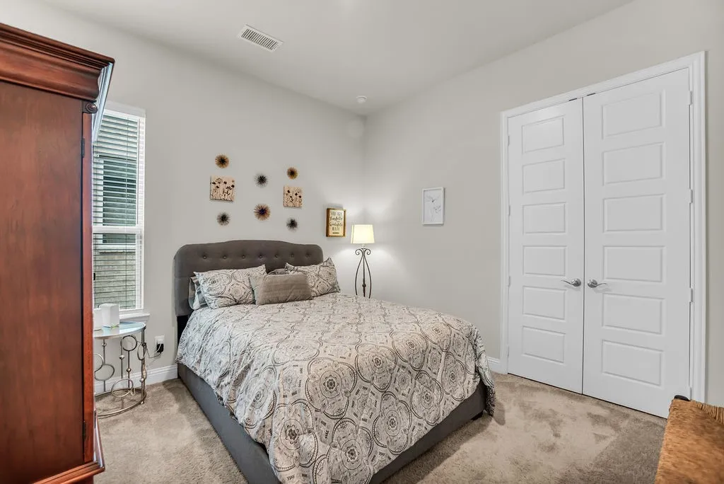 Plush carpet flooring, neutral paint palette, window with horizontal blinds, and white paneled doors