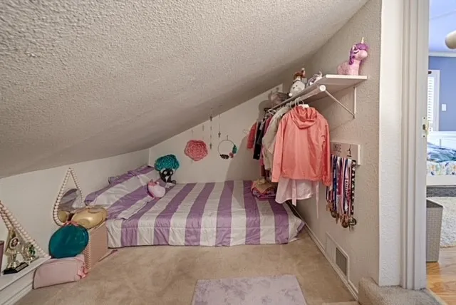 Sloped ceiling room featuring carpeting and built-in shelving