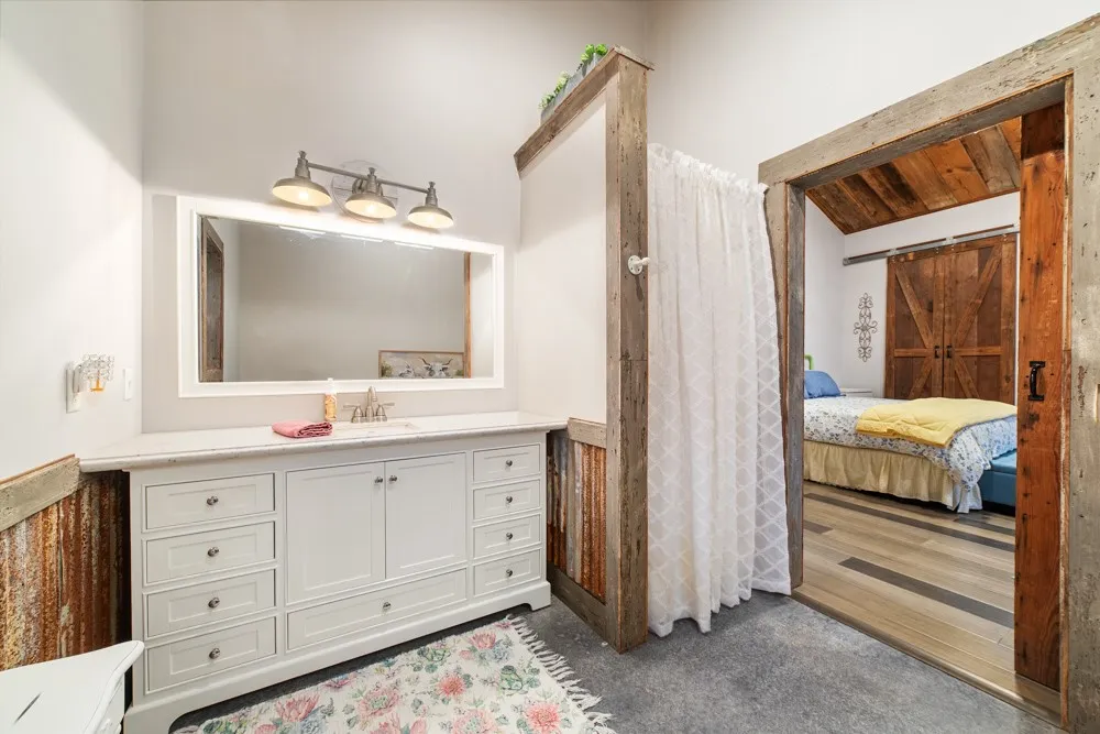 White vanity with integrated sink, rectangular framed mirror, and brushed nickel light fixture