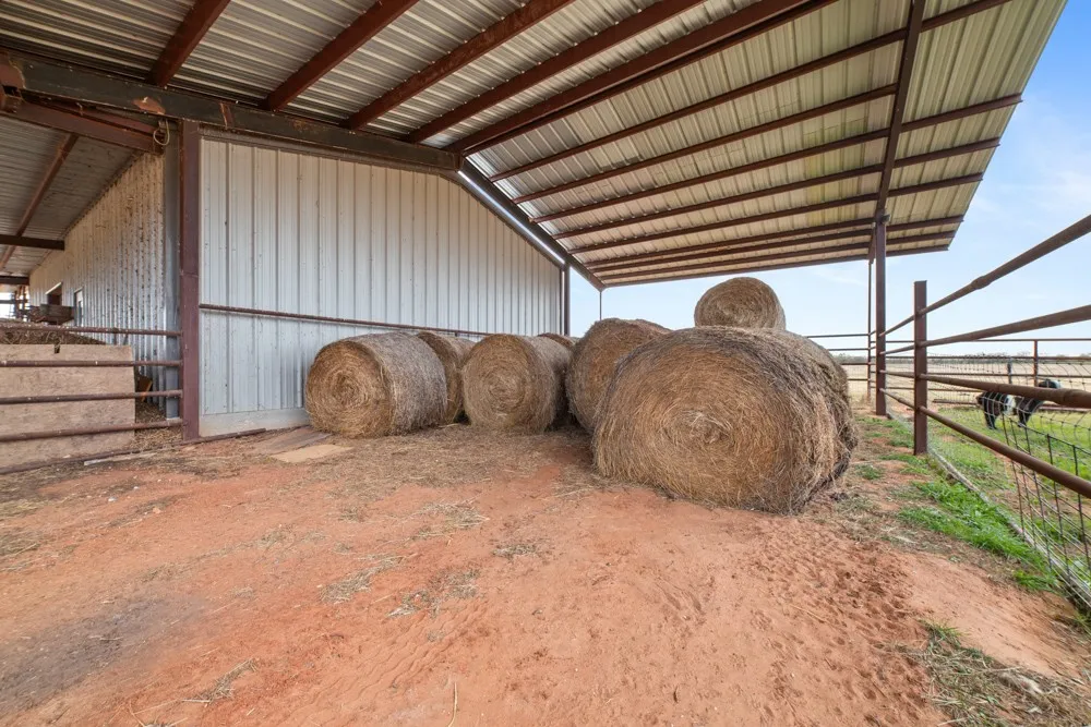 Enclosed barn structure featuring a corrugated metal roof and metal siding