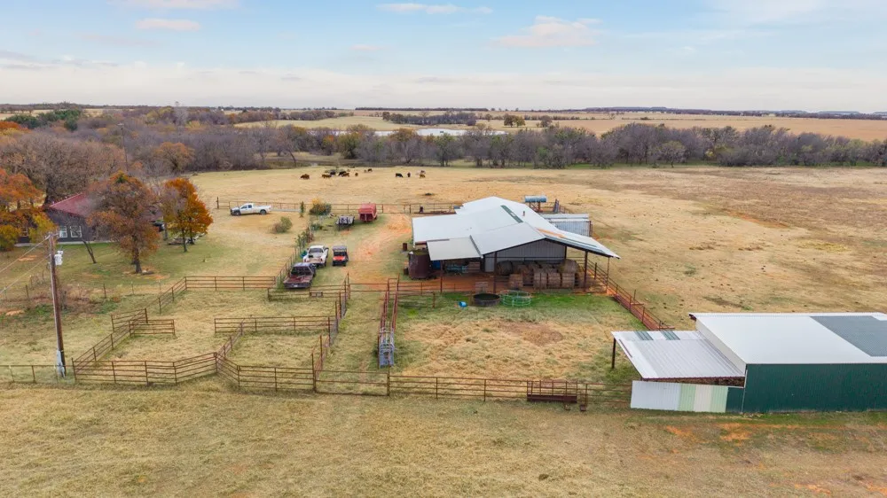 Expansive property featuring a residence, detached barn, and multiple fenced outdoor areas