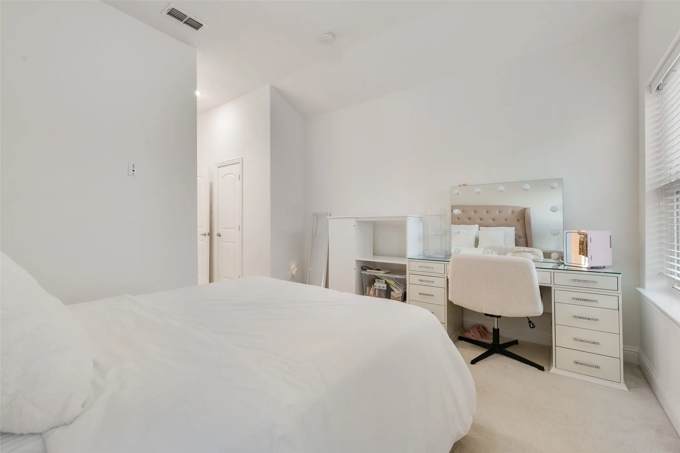 White interior walls, recessed ceiling lighting, light-toned carpeting, white window blinds