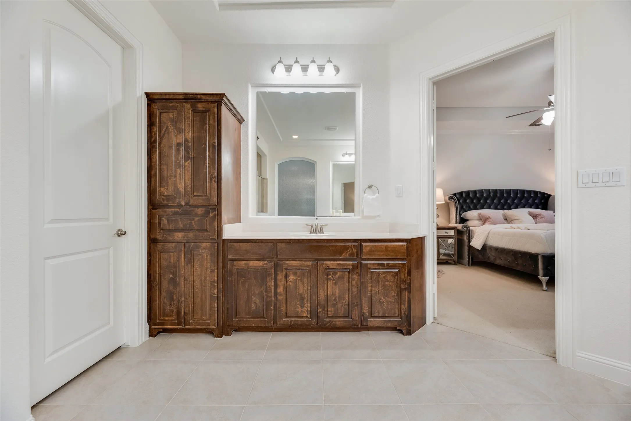 Bathroom vanity with a single sink, light-colored countertop, and a large mirror
