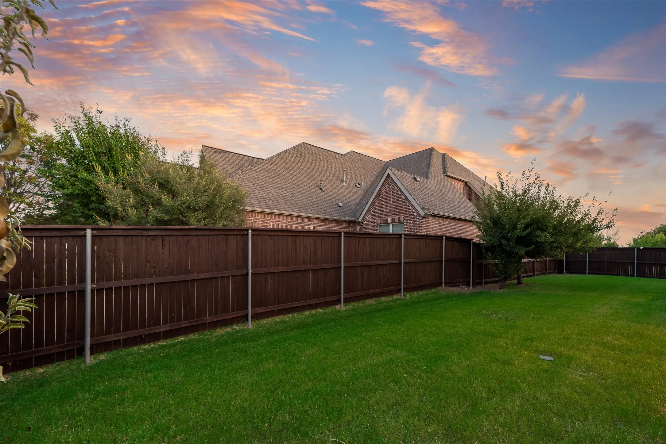 Expansive green lawn with a privacy fence