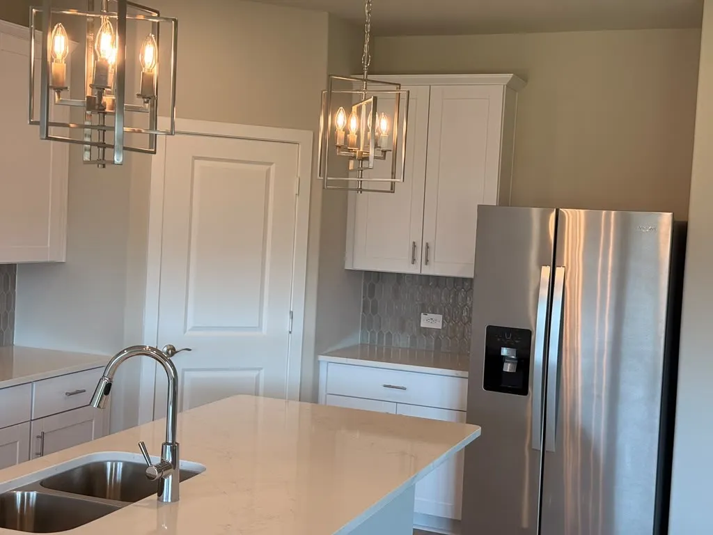 Quartz countertop island with an undermount double-basin sink and pull-down faucet