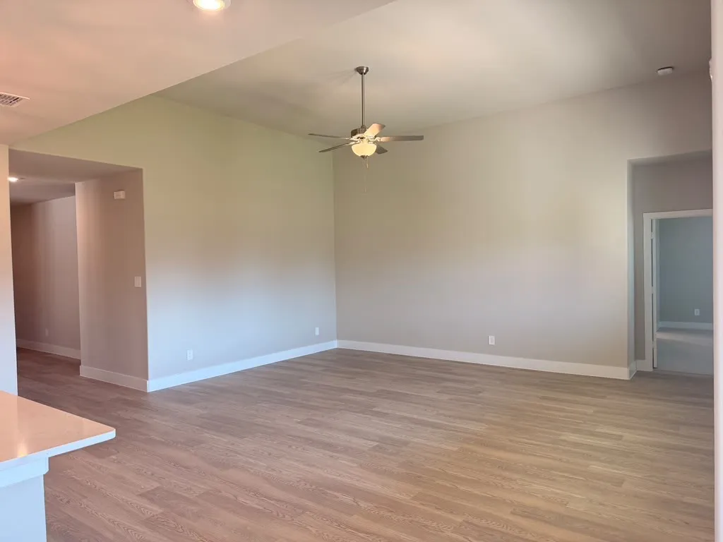 Vaulted ceiling with a ceiling fan, recessed lighting, and wood-finish flooring
