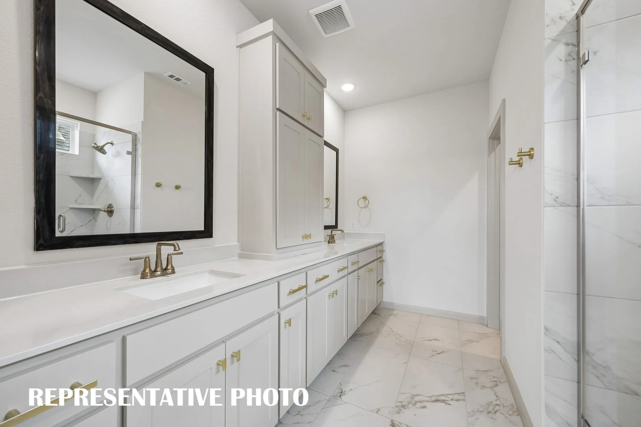 Featuring fantastic storage and dual vanities, this owner's bath offers ample room for two!  REPRESENTATIVE PHOTO