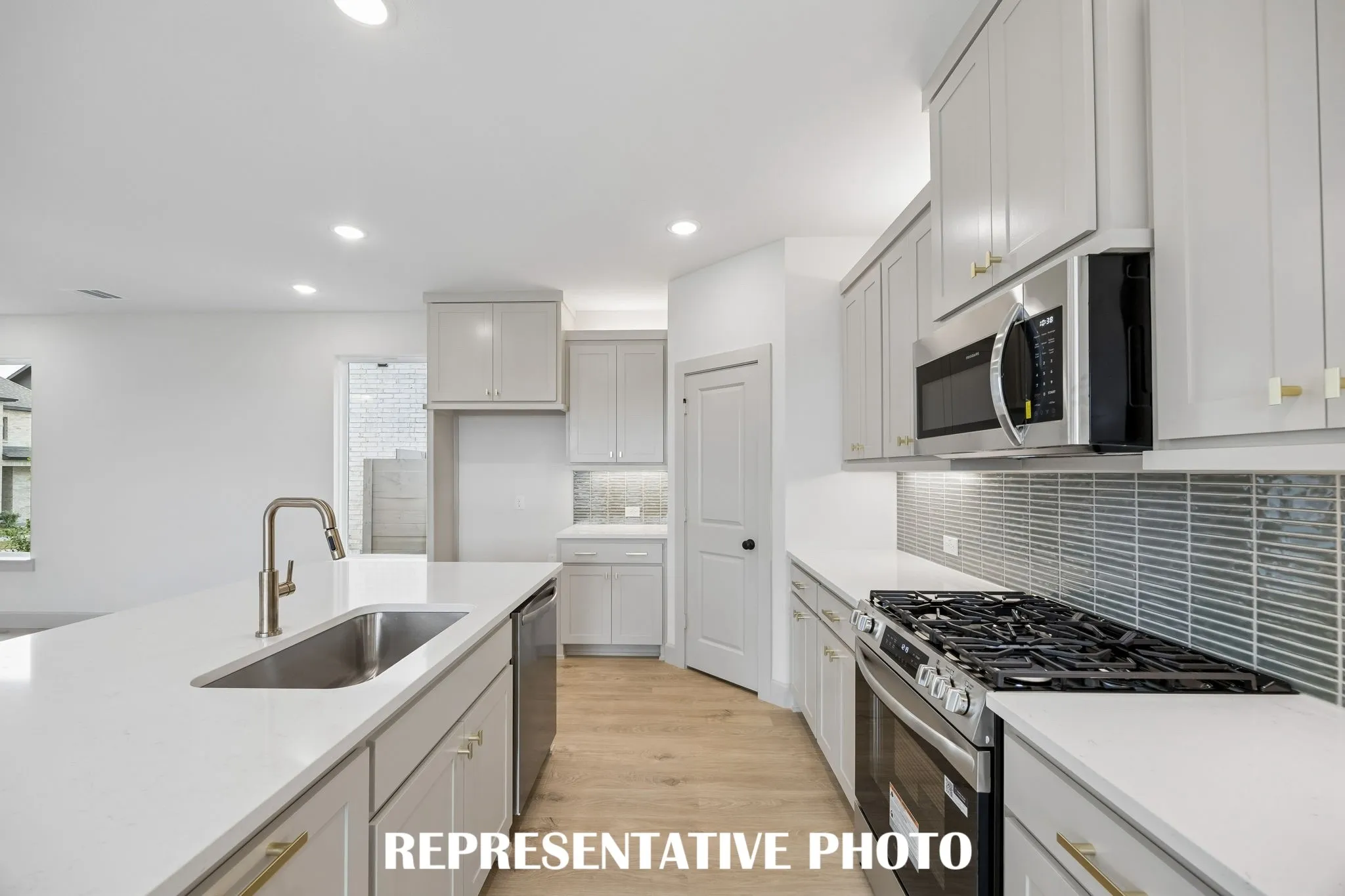 Beautiful cabinetry, gorgeous countertops and a stylish backsplash effortlessly blend with contemporary stainless steel to create a kitchen for the ages!  REPRESENTATIVE PHOTO