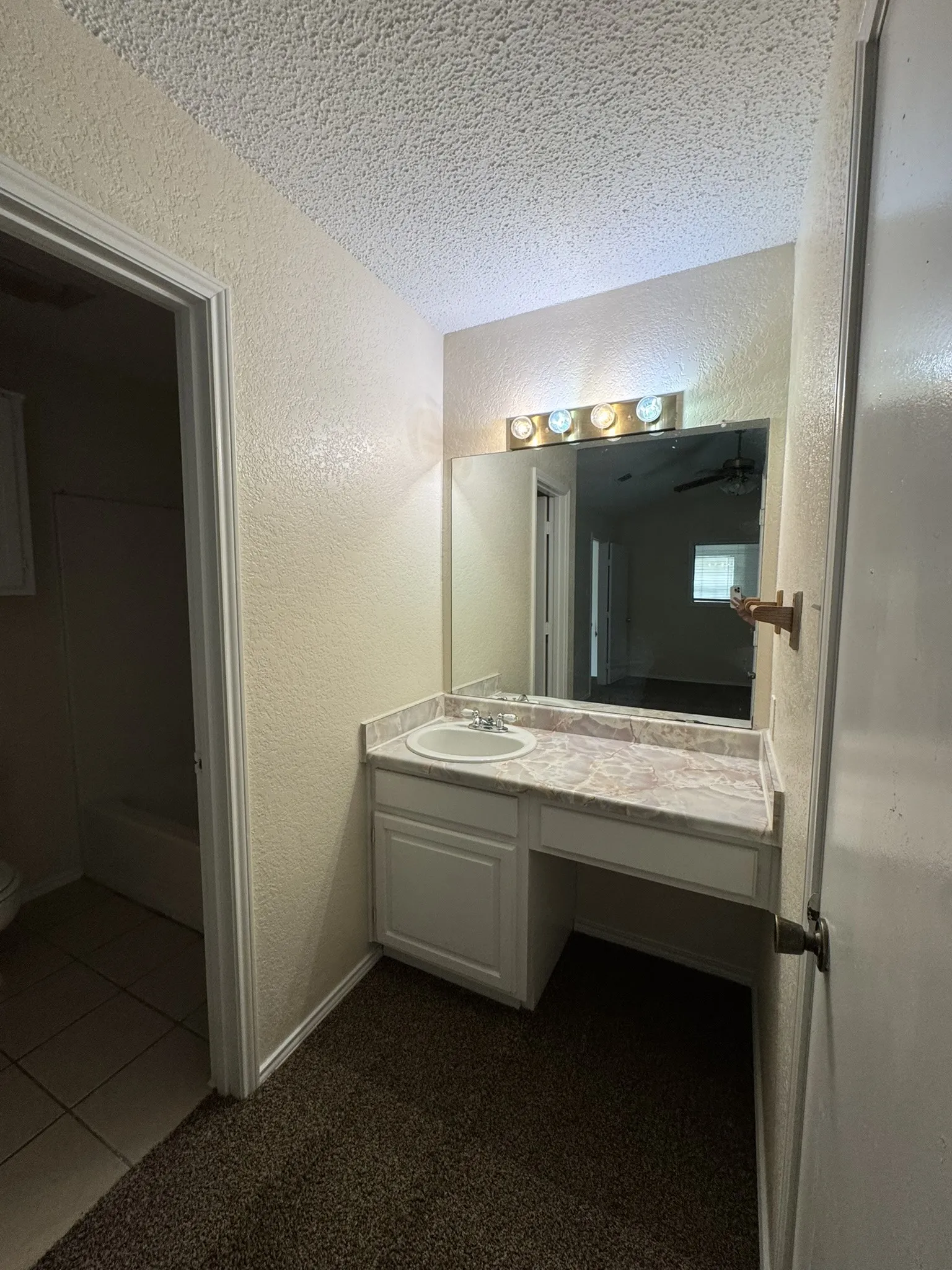 Vanity area with a built-in sink, white cabinetry, and a countertop