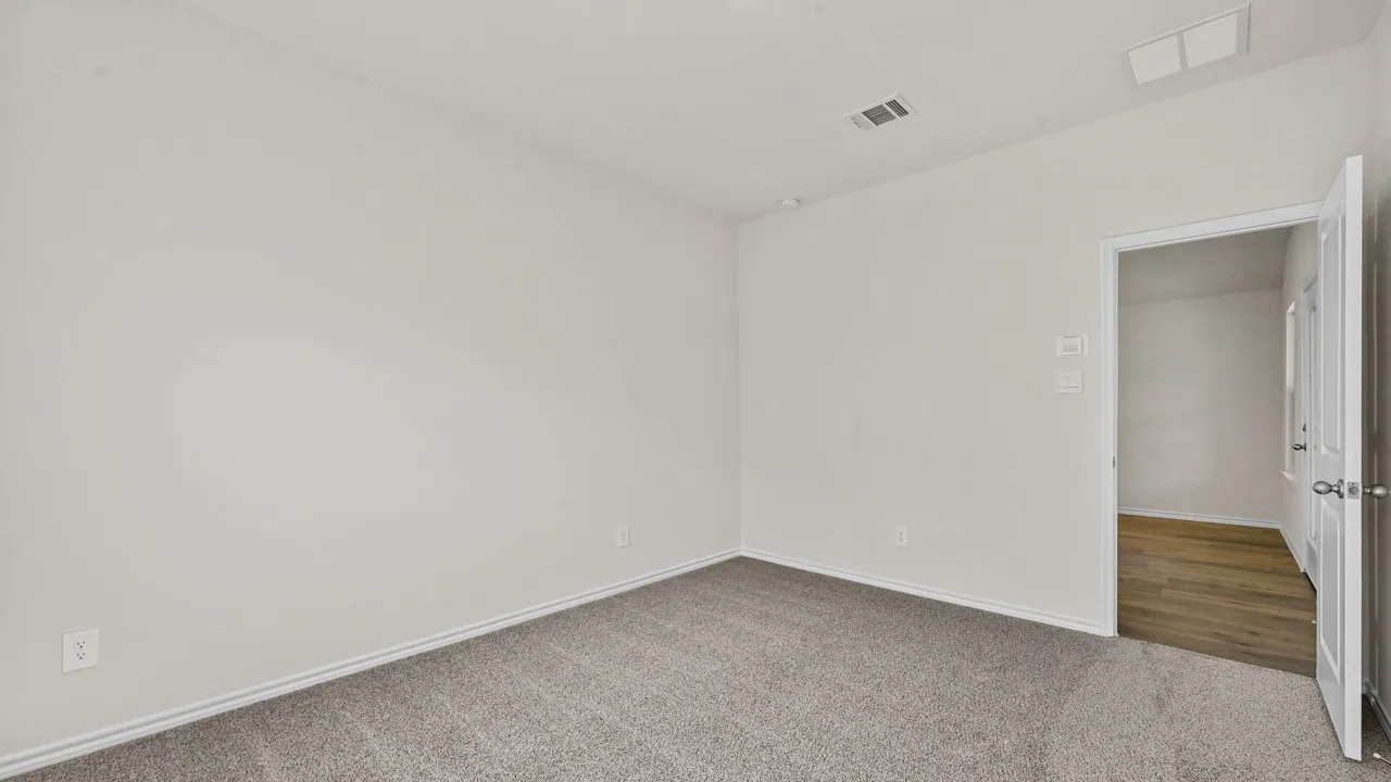 Neutral paint palette, gray carpet, white trim, recessed lighting, wood-finish flooring visible through doorway