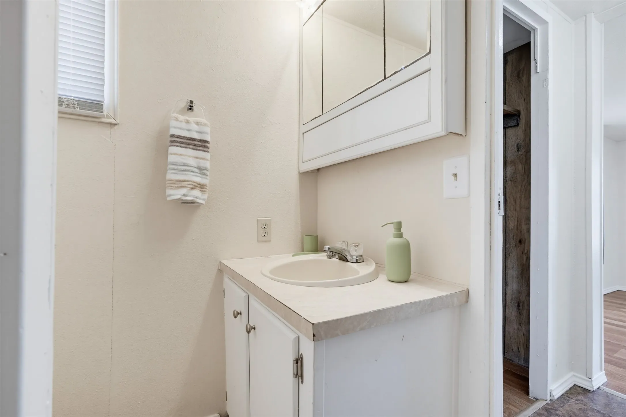 White vanity with an integrated sink and laminate countertop