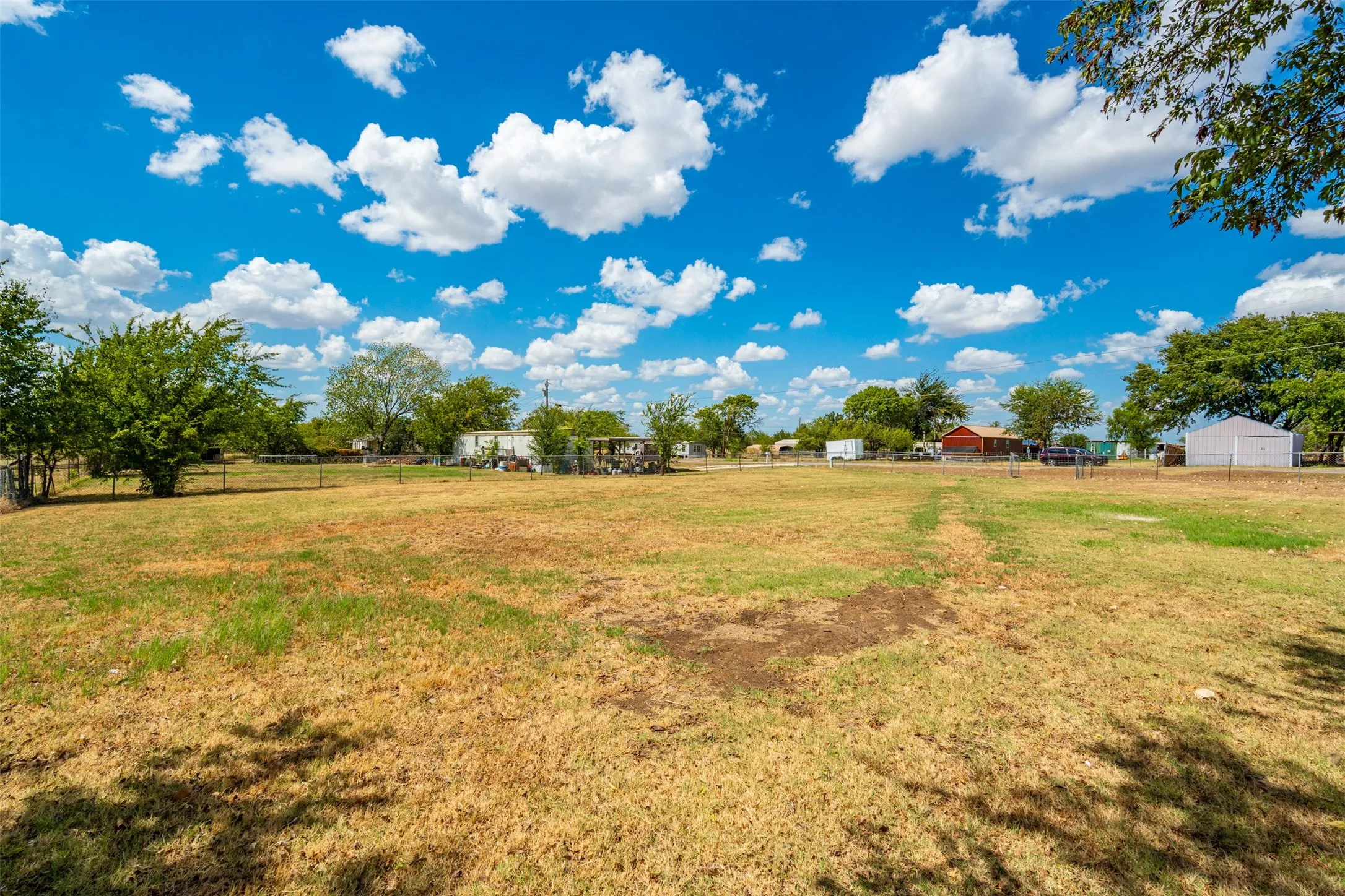 Expansive property featuring a mix of grass and natural ground cover