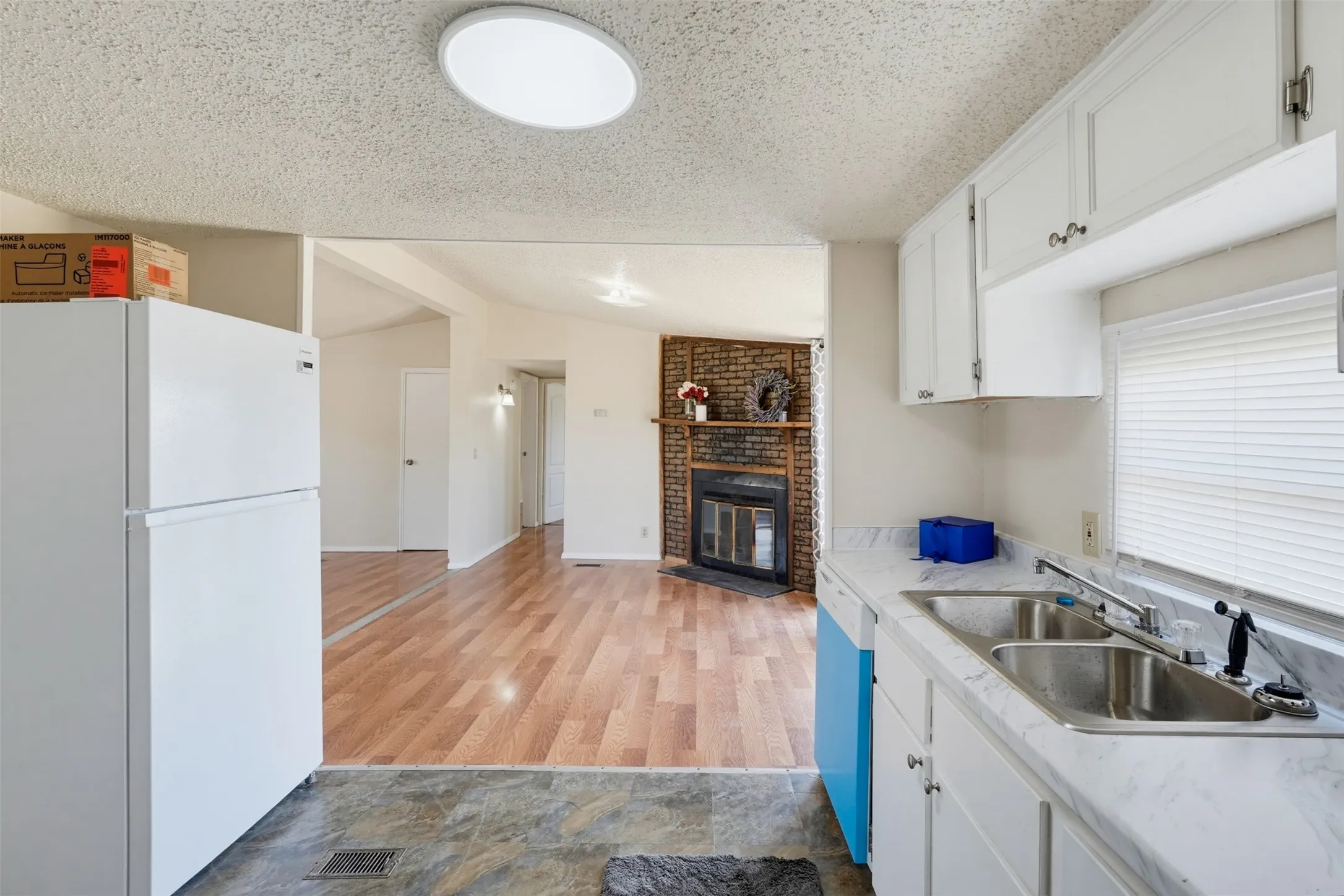 Kitchen with white cabinetry, double basin sink, and laminate countertops