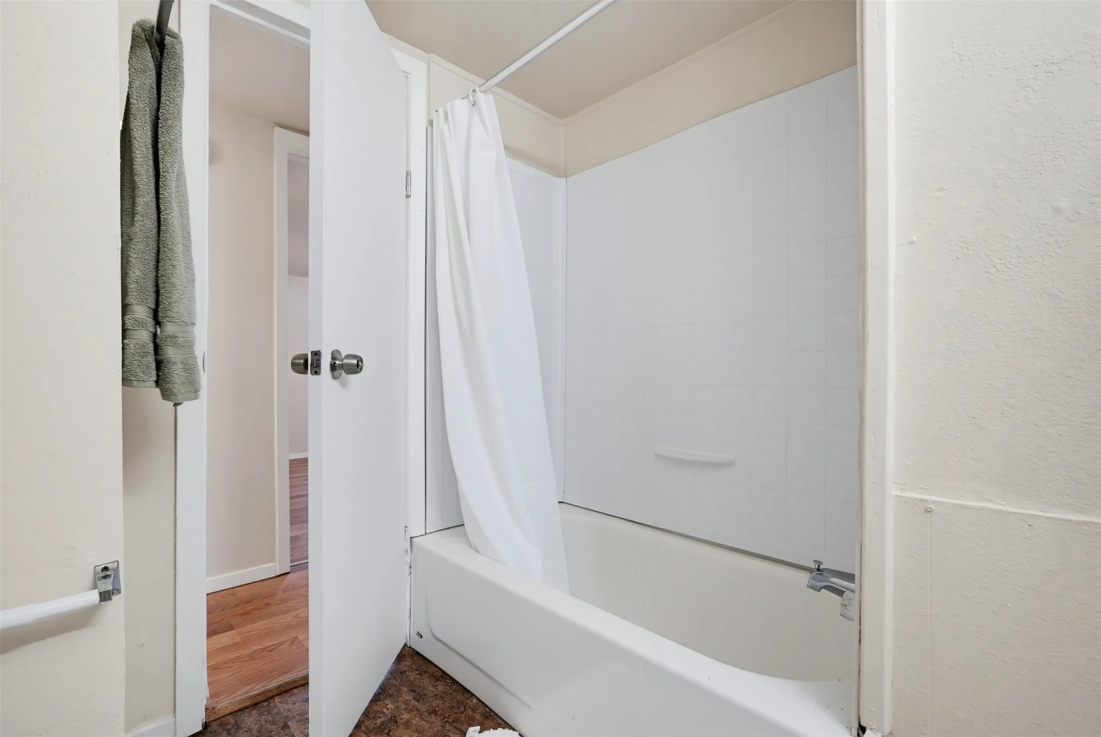 Bathtub with white surround and shower curtain rod