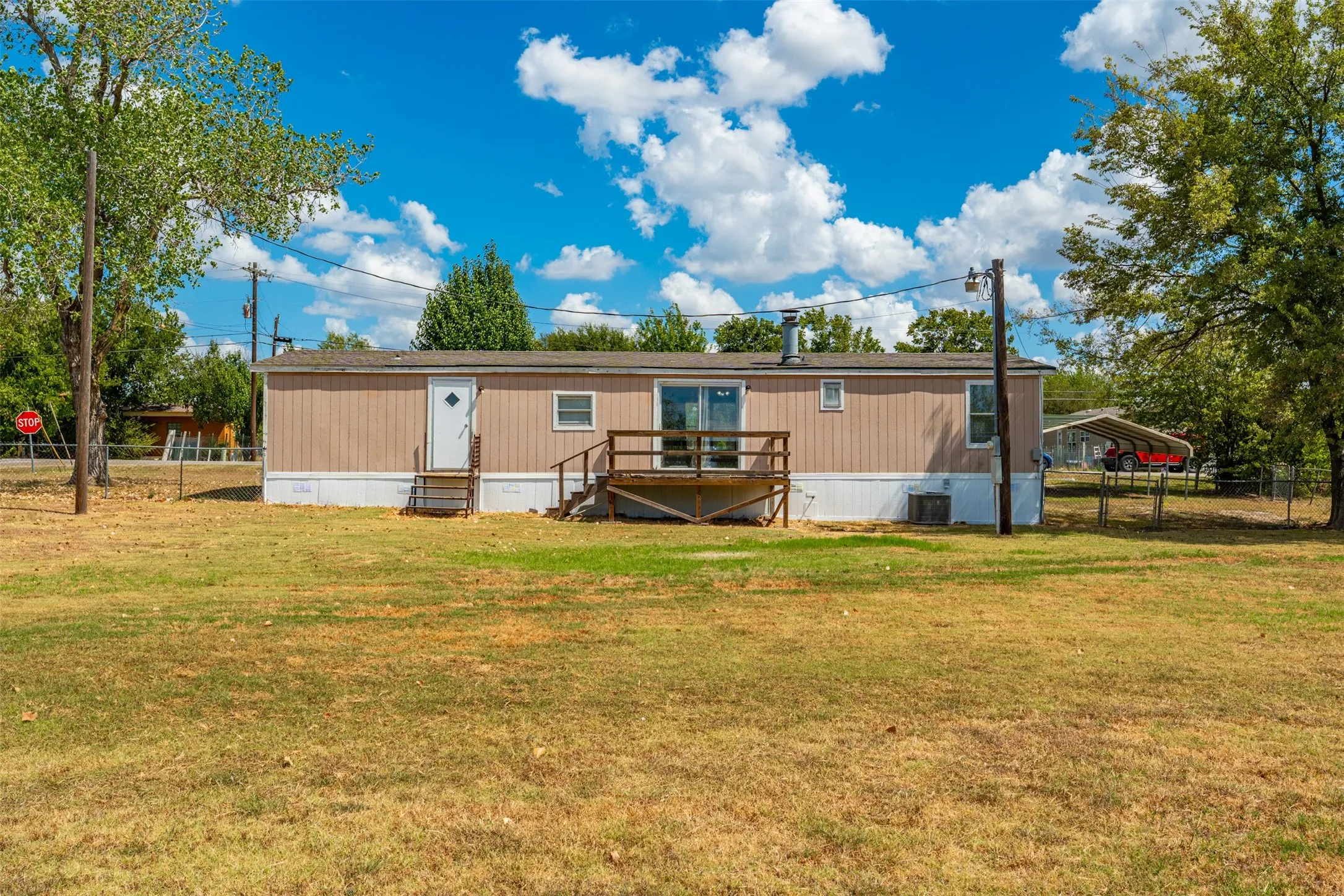 Property exterior with horizontal siding, two entry doors, and a wood deck