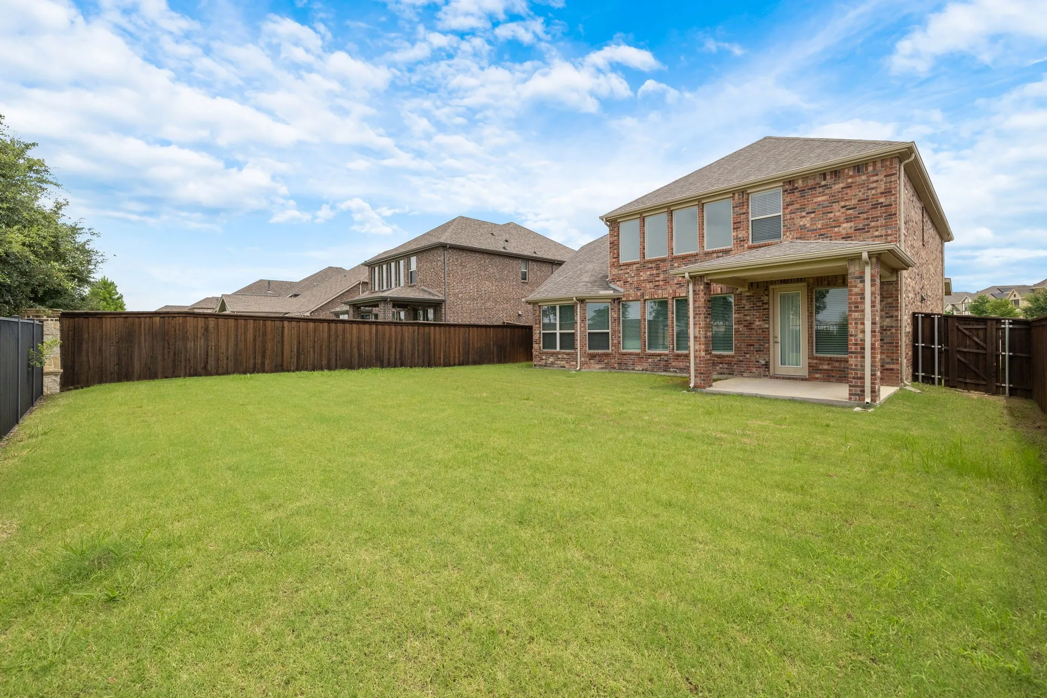 Expansive grass lawn with a full privacy fence