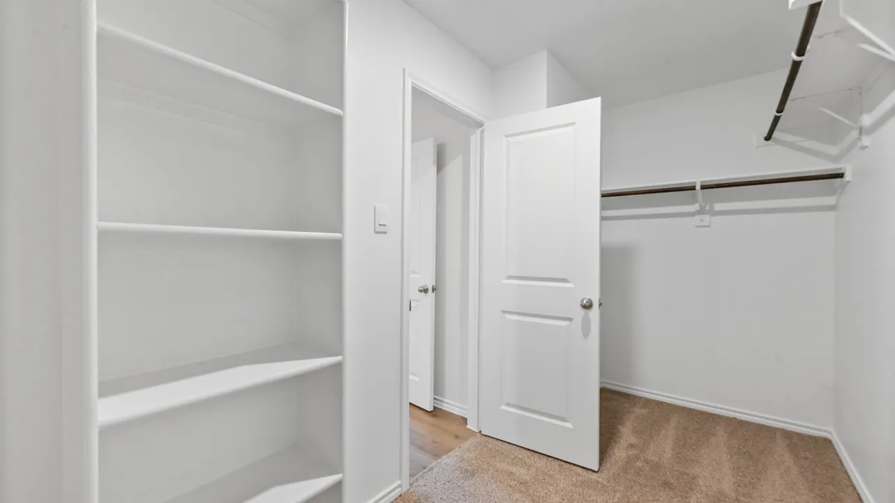 Built-in shelving unit providing organized storage, complemented by a separate closet area with hanging rods