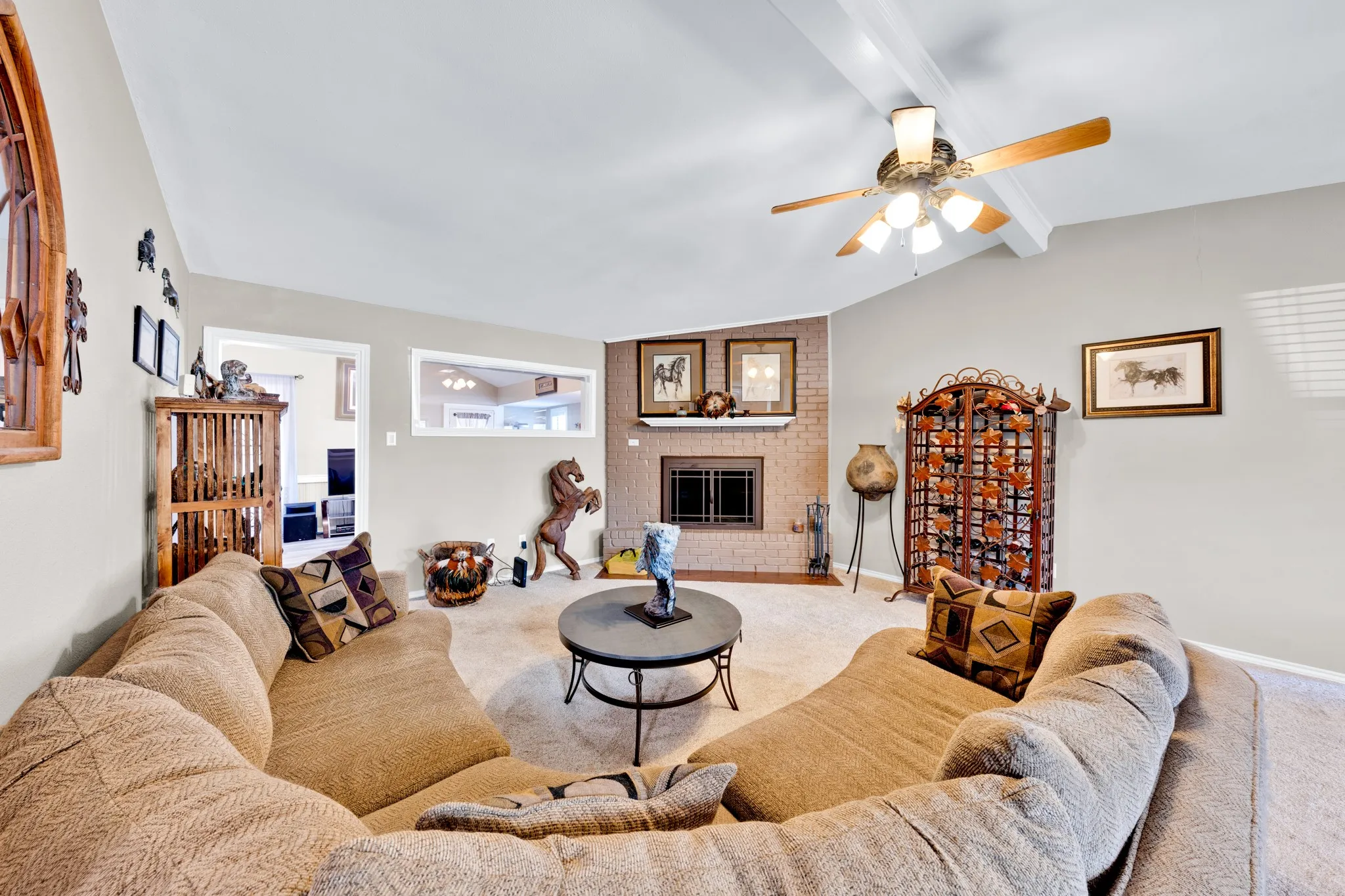 Vaulted ceiling with exposed beams and a ceiling fan