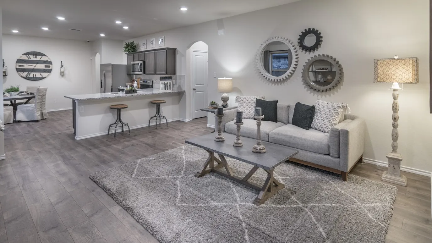 Open-concept living space featuring wood-finish flooring, recessed lighting, a kitchen island with seating, a built-in microwave, and arched doorways
