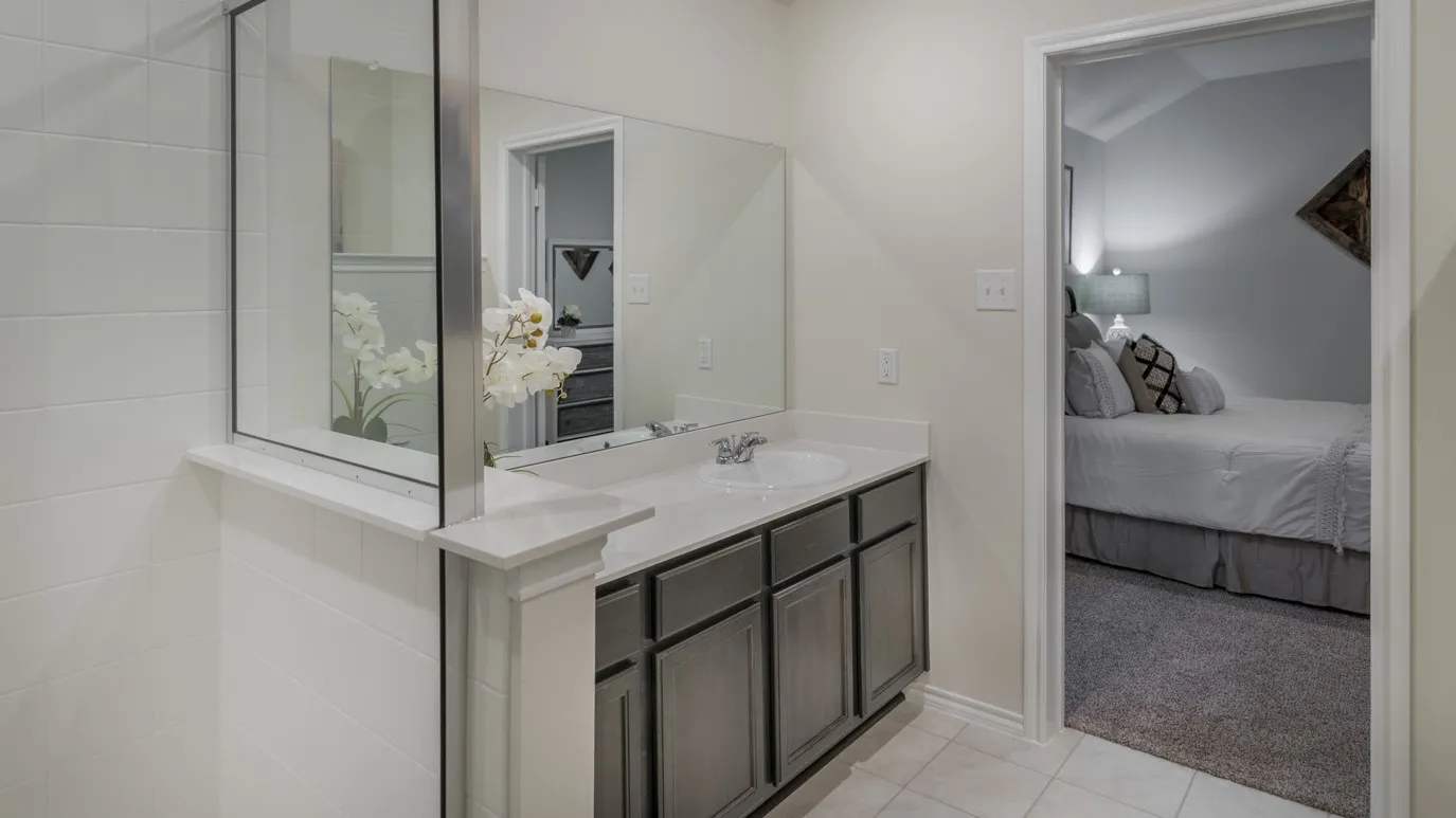 Bathroom vanity with a white countertop and undermount sink, complemented by gray cabinetry