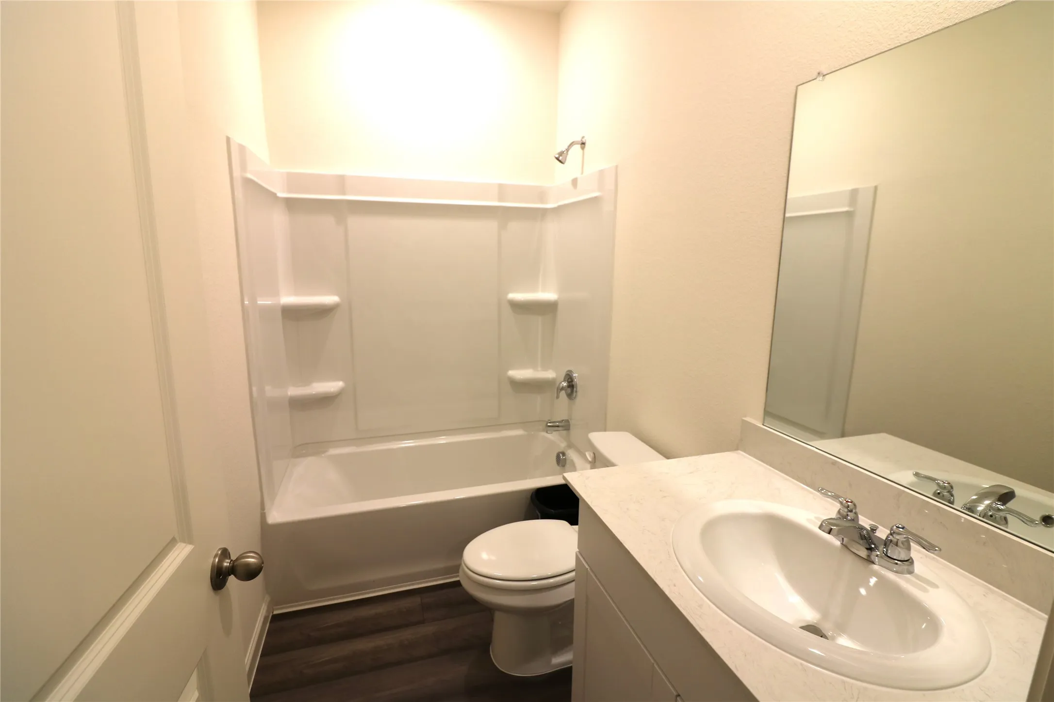 White vanity with an integrated sink, polished chrome faucet, and expansive wall-mounted mirror