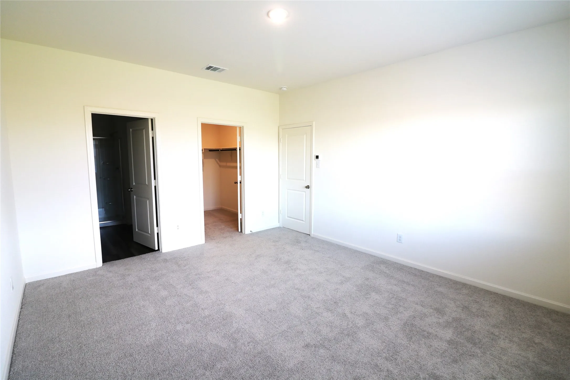 Neutral tone wall paint, recessed lighting, and soft gray carpeting