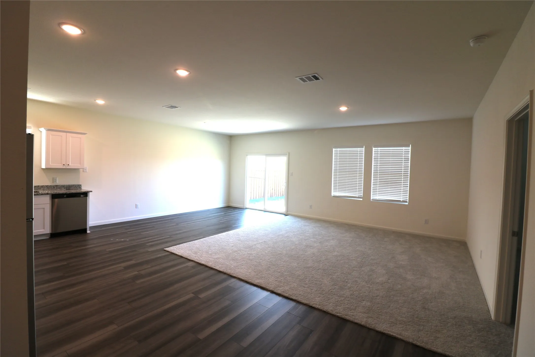 Expansive room featuring wood-finish flooring, recessed lighting, and a neutral color palette